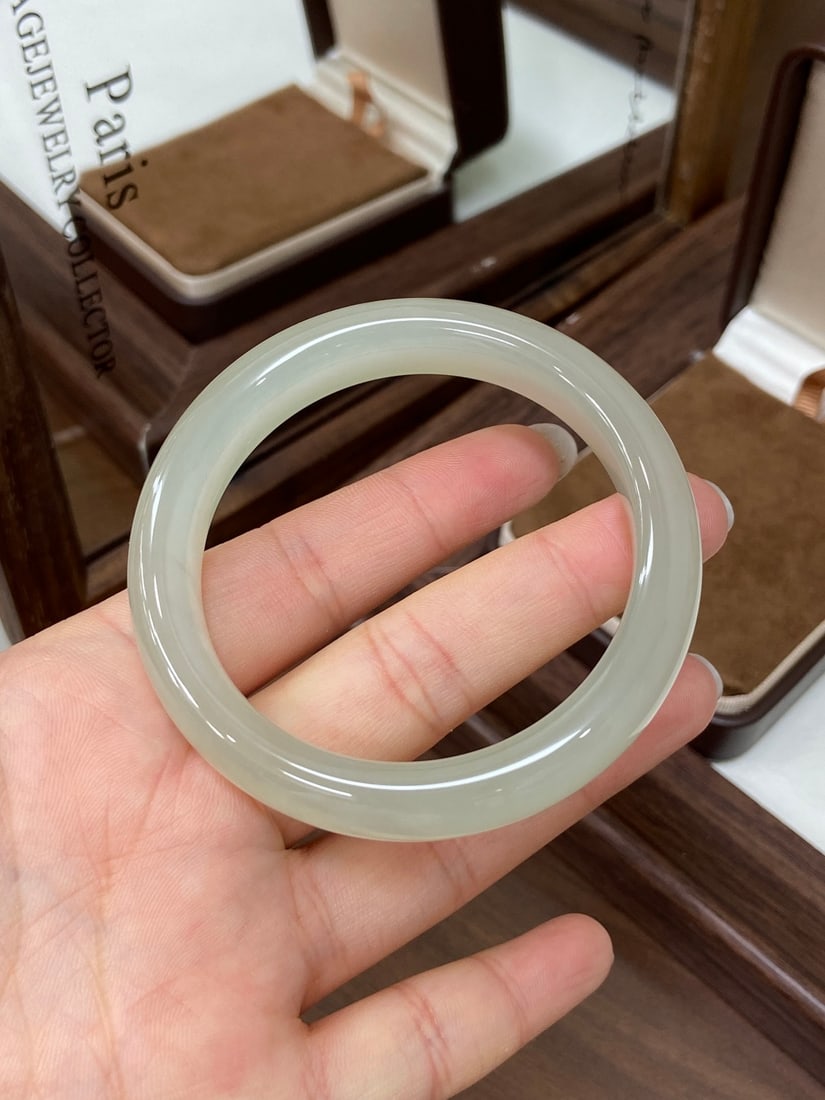 An Exquisite Ge yao Yellow Glazed Inlaid Silver Double-Ears Vase: A finely carved Hetian jade bangle of high-ice translucency, of round form, exhibiting a remarkable 'qijiao' (gel-like) luster and exceptional clarity. The jade is of fine, icy texture with a rigid, b