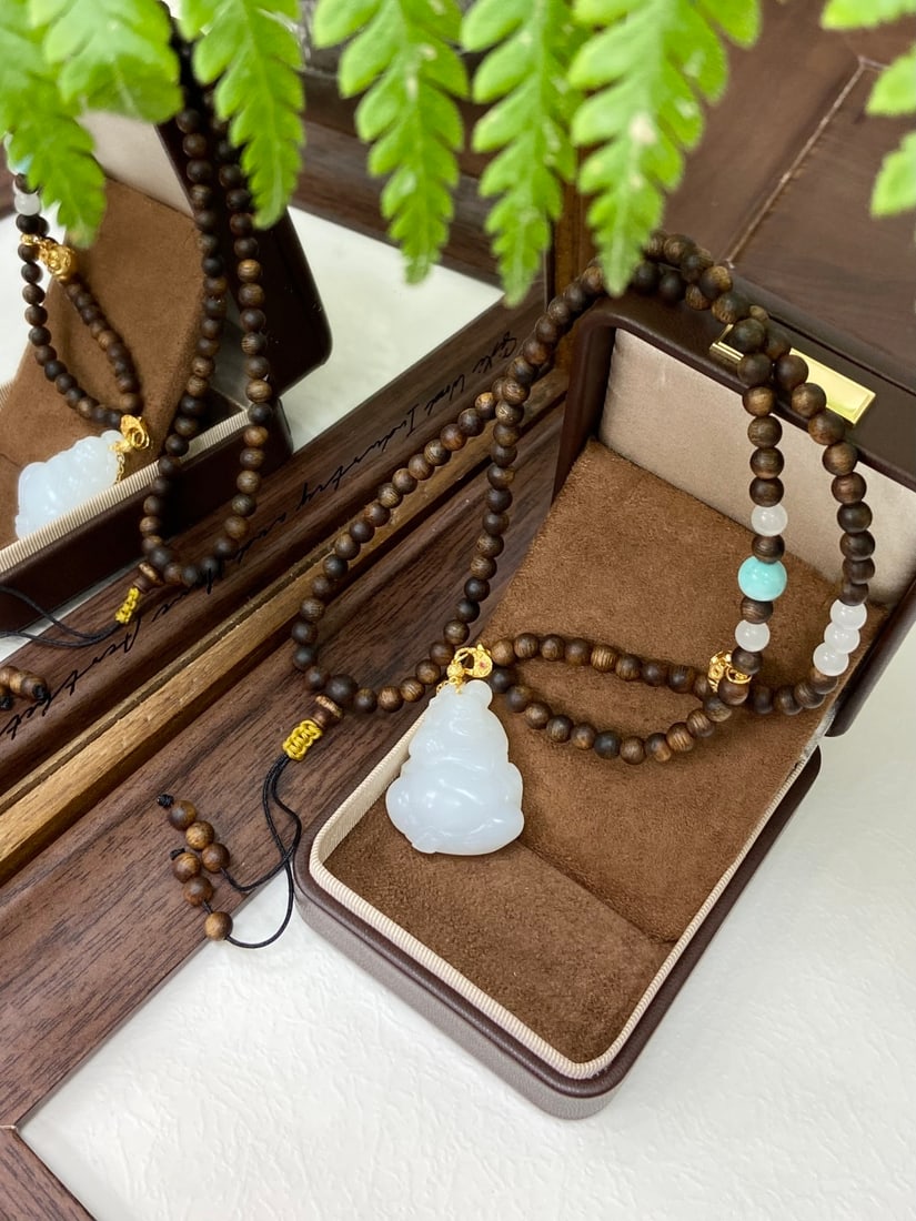 A Huge Gilt Bronze Statue of Figure: A finely carved Hetian jade pendant of 'yangzhi' (mutton-fat) white quality, carved as a seated Maitreya Buddha, accompanied by a 4mm agarwood chain and 8mm turquoise beads. The jade is of exceptional