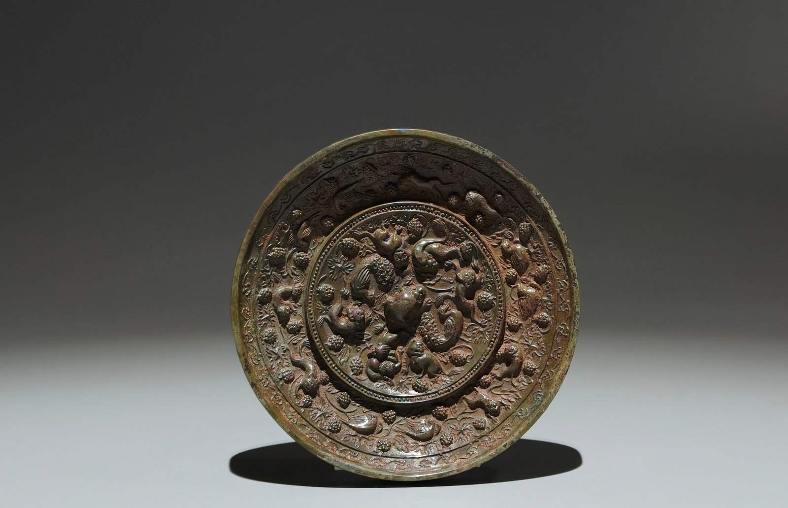 An Exquisite Ruby Red-Glazed Painted Gold Auspicious Cloud and Phoenix Pattern Pot: An Archaic Bronze Auspicious Beast and Grapes Pattern Round Mirror,Tang Dynasty,China,Size:4.6in 青铜瑞兽葡萄纹镜,中国唐代
