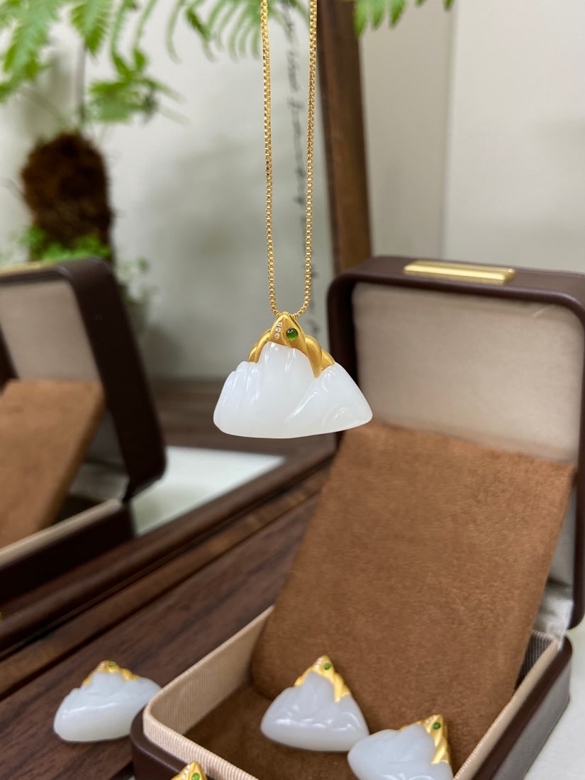 An Exquisite Turquoise Glazed Famille-Rose Painted Gold Flower and Butterfly Pattern Vase: A finely carved Hetian jade pendant of 'yangzhi' (mutton-fat) white quality, set in 18K gold, carved as a mountain, symbolizing stability and support. The jade is of fine, white texture with a warm, o