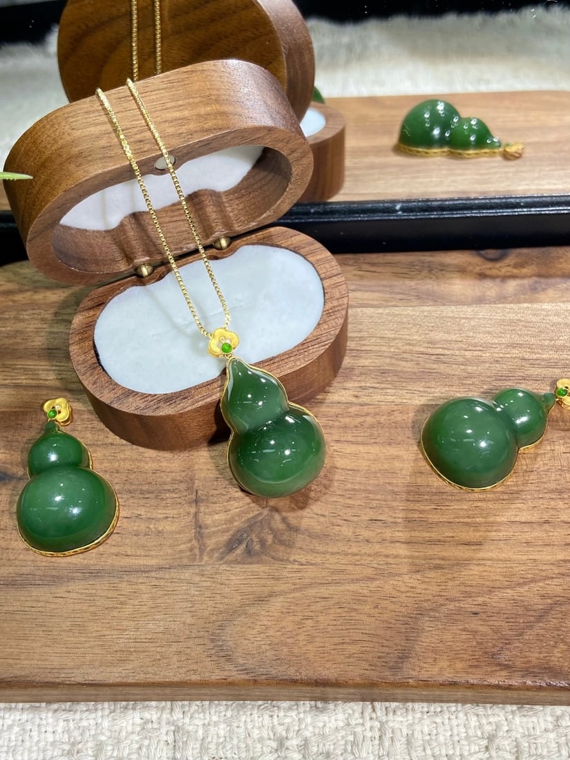 An Exquisite Turquoise Glazed Famille-Rose Painted Gold Lotus Pattern Vase: A finely carved Hetian jade pendant of spinach-green tone, carved as a gourd, a symbol of blessing and prosperity, set in 18K gold. The jade is of rich, even color with a smooth, warm finish. The pend