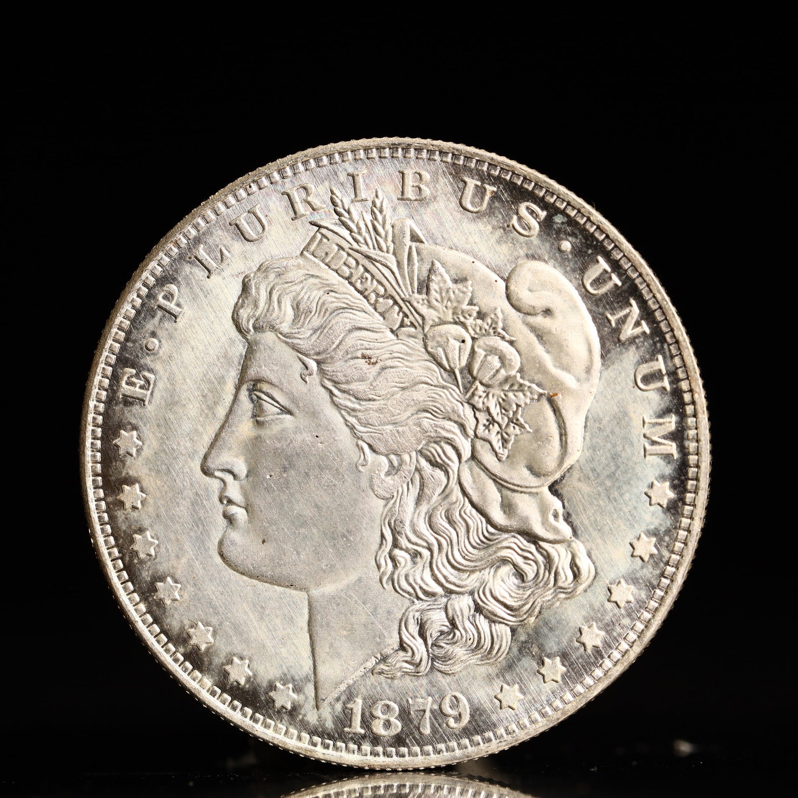 USA Morgan Dollar 1879 Coin: Obv: profile bust with date below and E PLURIBUS UNUM legend and stars around. Rev: eagle with In God we trust above within wreath with UNITED STATES OF AMERICA ONE DOLLAR legend. IN GOD WE TRUST / LI