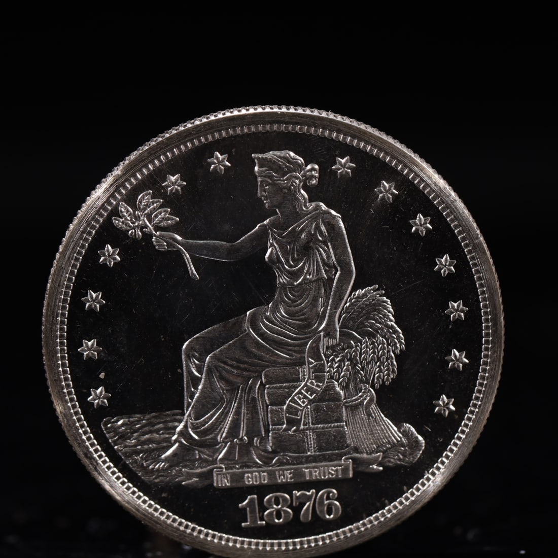 USA Trade Dollar 1876 Coin: American coin. Obverse: Liberty seated on a pedestal facing the sea to the left holding olive branches surrounded by 13 stars. IN GOD WE TRUST / LIBERTY / 1876. Reverse: An eagle holding branches with