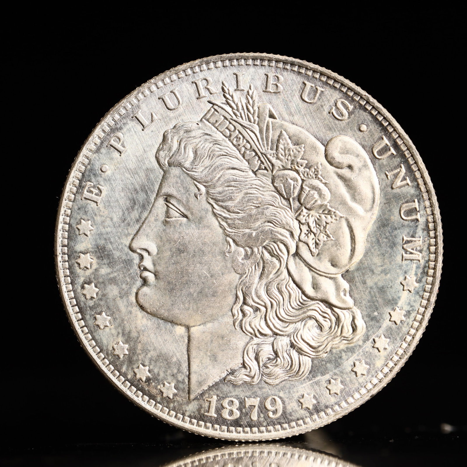USA Morgan Dollar 1879 Coin: Obv: profile bust with date below and E PLURIBUS UNUM legend and stars around. Rev: eagle with In God we trust above within wreath with UNITED STATES OF AMERICA ONE DOLLAR legend. IN GOD WE TRUST / LI