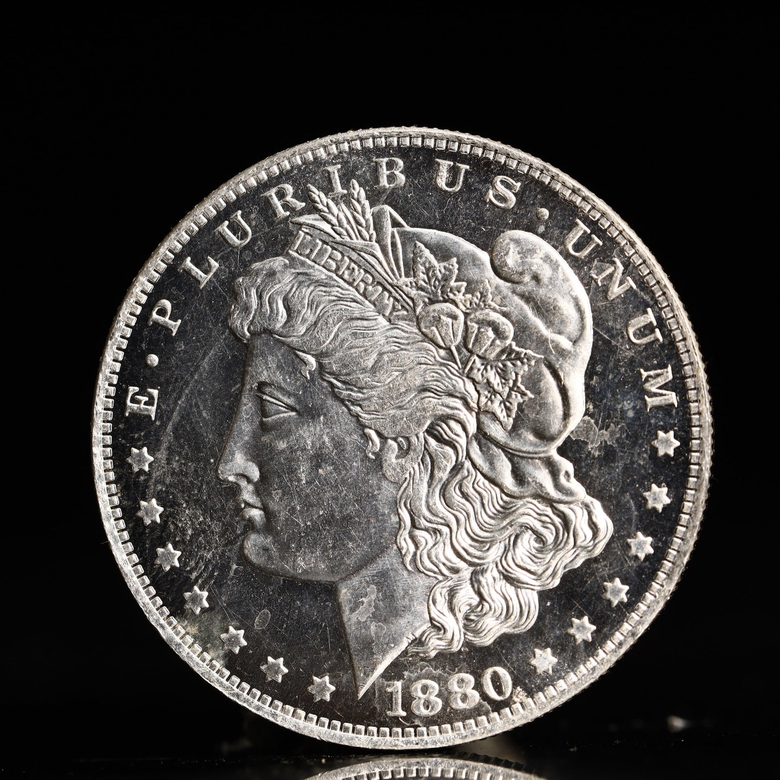 USA Morgan Dollar 1880 Coin: Obv: profile bust with date below and E PLURIBUS UNUM legend and stars around. Rev: eagle with In God we trust above within wreath with UNITED STATES OF AMERICA ONE DOLLAR legend. IN GOD WE TRUST / LI