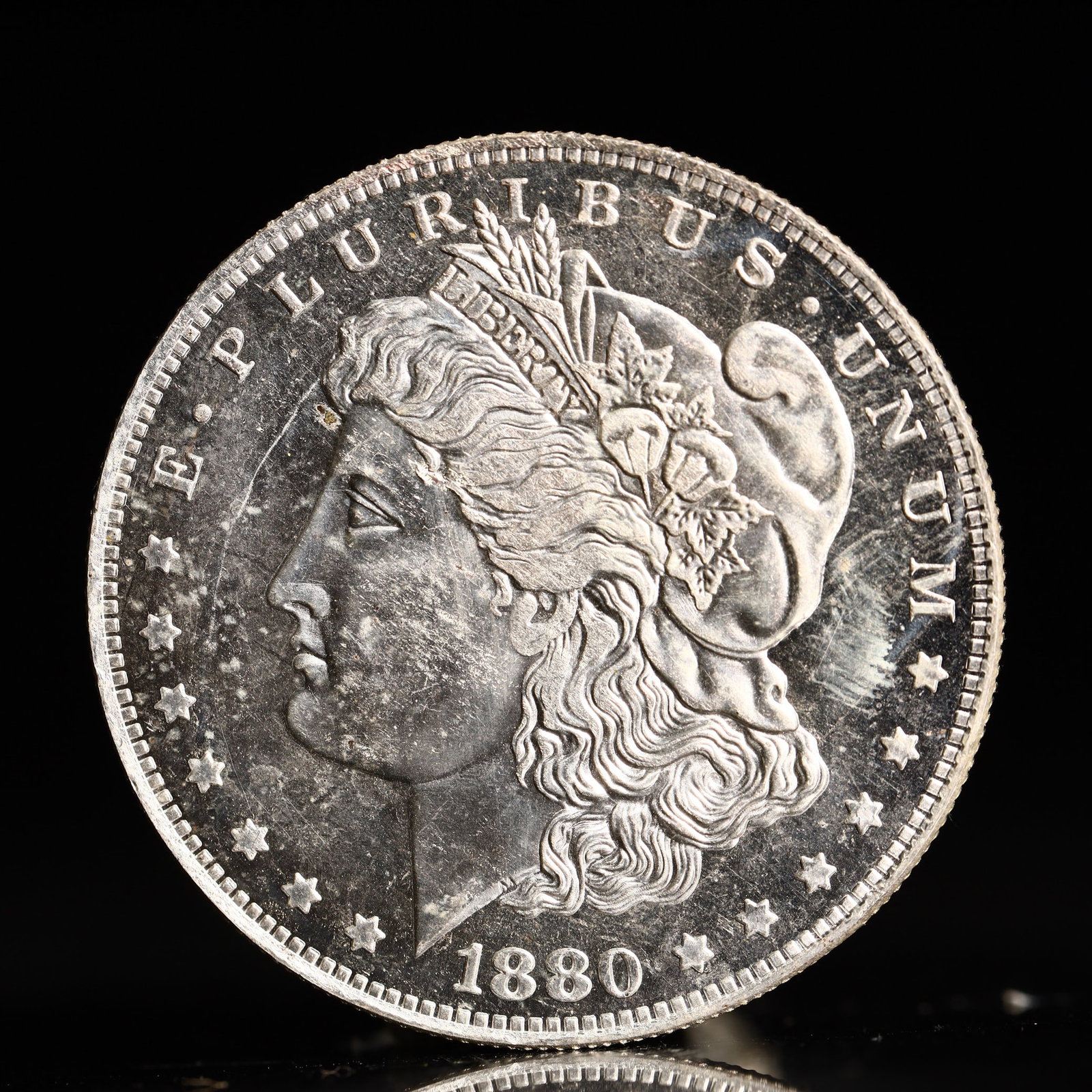 USA Morgan Dollar 1880 Coin: Obv: profile bust with date below and E PLURIBUS UNUM legend and stars around. Rev: eagle with In God we trust above within wreath with UNITED STATES OF AMERICA ONE DOLLAR legend. IN GOD WE TRUST / LI