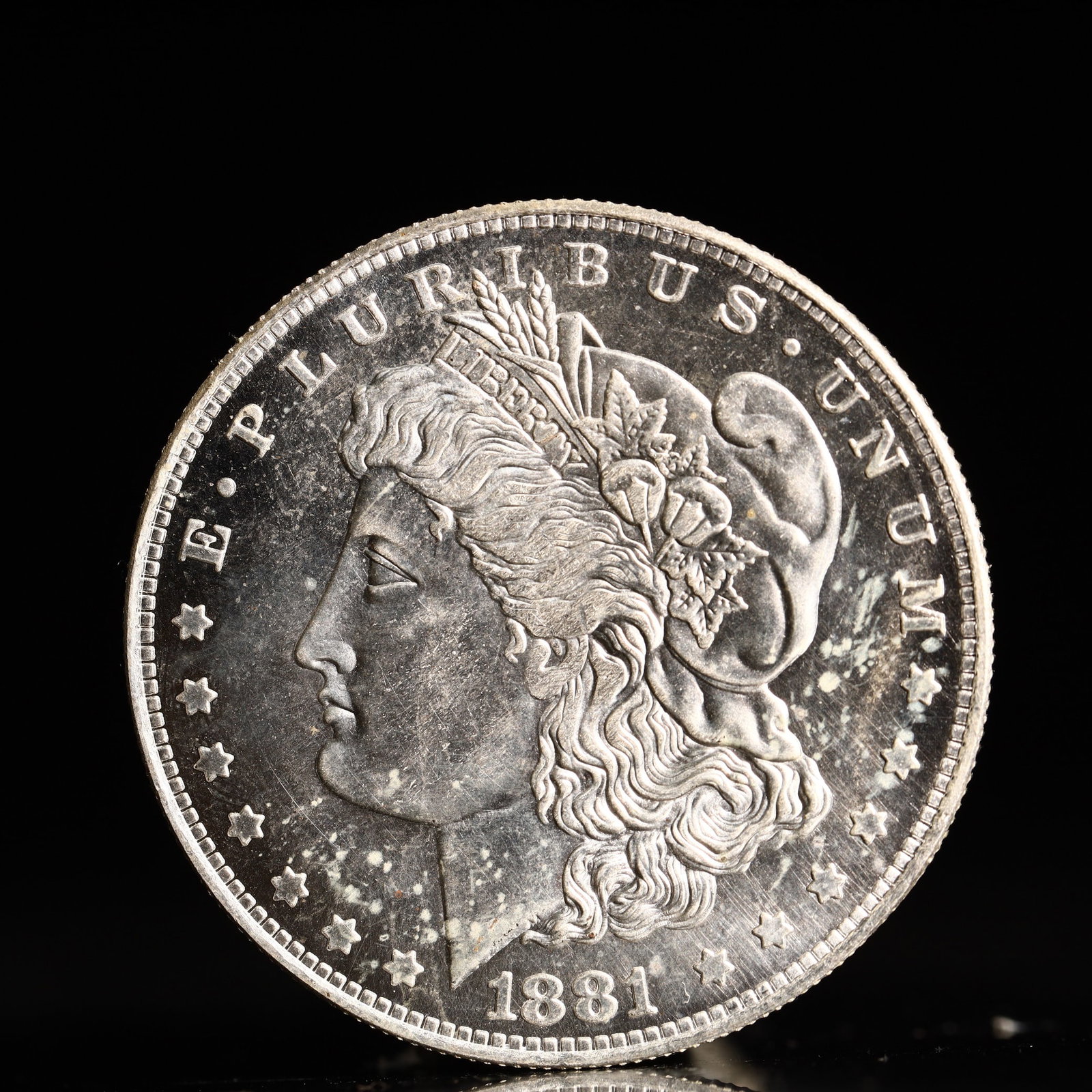 USA Morgan Dollar 1881 Coin: Obv: profile bust with date below and E PLURIBUS UNUM legend and stars around. Rev: eagle with In God we trust above within wreath with UNITED STATES OF AMERICA ONE DOLLAR legend. IN GOD WE TRUST / LI