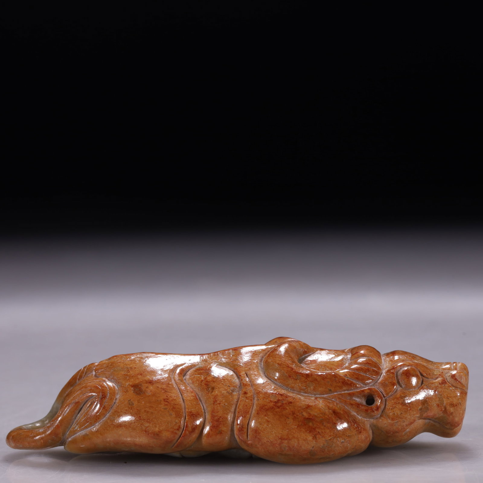 Hongshan Culture Yellow Jade Mythical Beast Looking Back: Carved in the round as a recumbent mythical beast looking backwards, with limbs tucked beneath, a rounded arched back, and an unfinished central hole at the neck. The fine yellow jade is enriched with