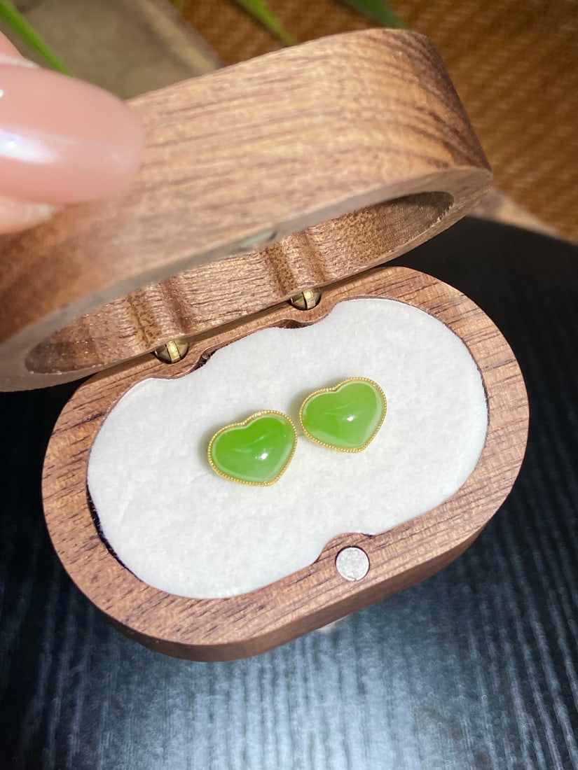 A Finely Carved Hetian Jade 'Apple Green' Heart-Shaped Earrings: A finely carved Hetian jade earrings of apple-green tone, of heart-shaped form, set in 18K gold. The jade is of fine, icy texture with a fresh, vibrant hue. The earrings measure 10.5mm by 8.5mm. Ø