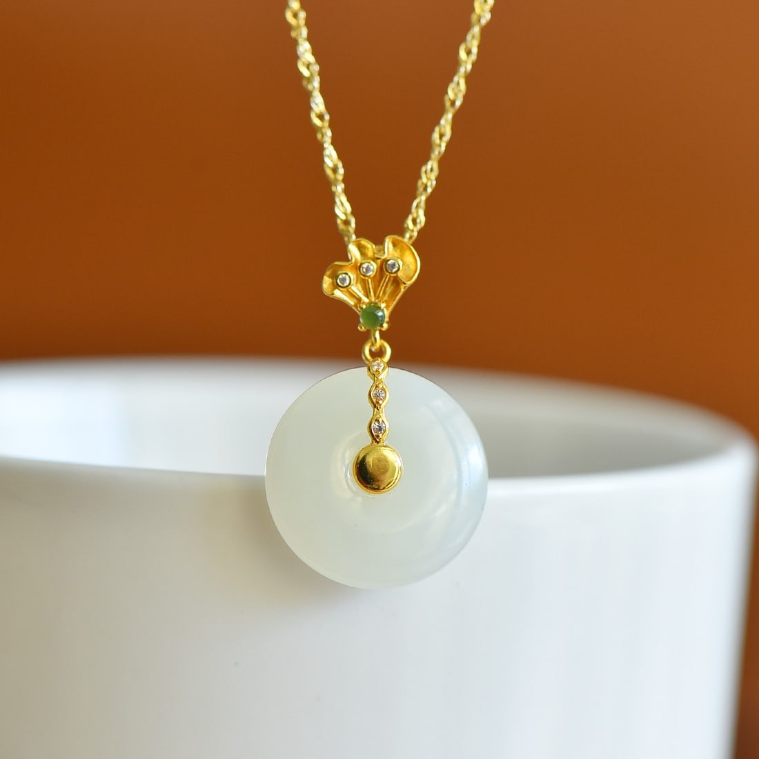 A Sterling Silver and White Jade 'Ping'an' Buckle Pendant: A sterling silver pendant set with a white jade 'Ping'an' buckle of plain circular 'Bi'-disc form, Sise: 18mm×18 mm.