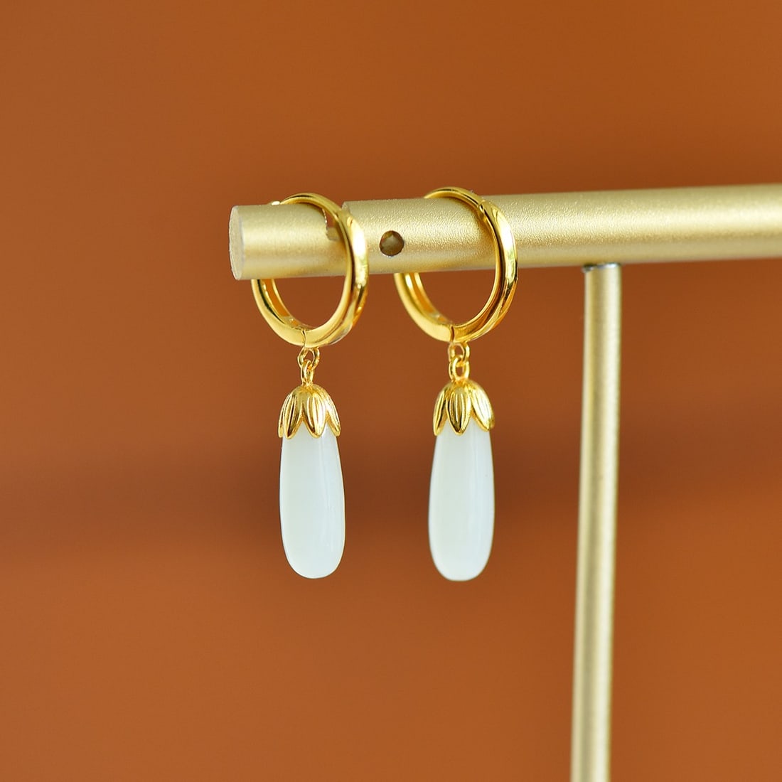A Pair of Sterling Silver and White Jade Earrings: A pair of sterling silver earrings, each set with white jade, Sise: 5mm×14 mm. 纯银镶白玉耳扣；主石为白玉.