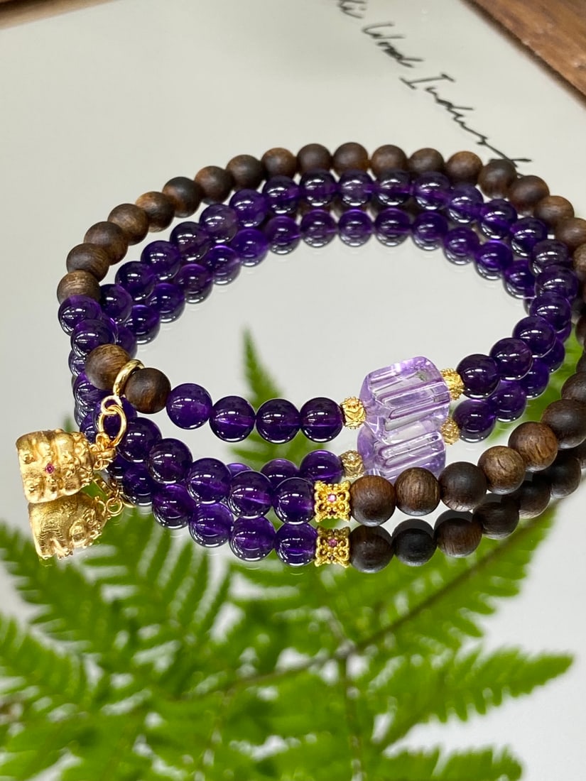 A Finely Carved Natural Amethyst and Agarwood Double-Strand Bracelet: A finely carved bracelet composed of natural amethyst beads (5.5mm) and agarwood beads, of new Chinese style, offering a harmonious blend of crystal-clear purple and warm woody fragrance. The bracelet