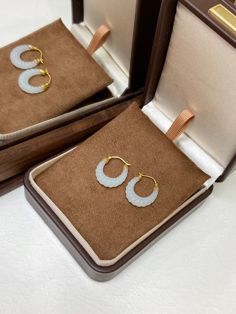 A Finely Carved Hetian Jade 'Yangzhi' White Jade Earrings: A finely carved Hetian jade earrings of 'yangzhi' (mutton-fat) white quality, of twisted-rope form, set in 18K gold. The jade is of fine, oily texture with a smooth, warm finish. The earrings measure 