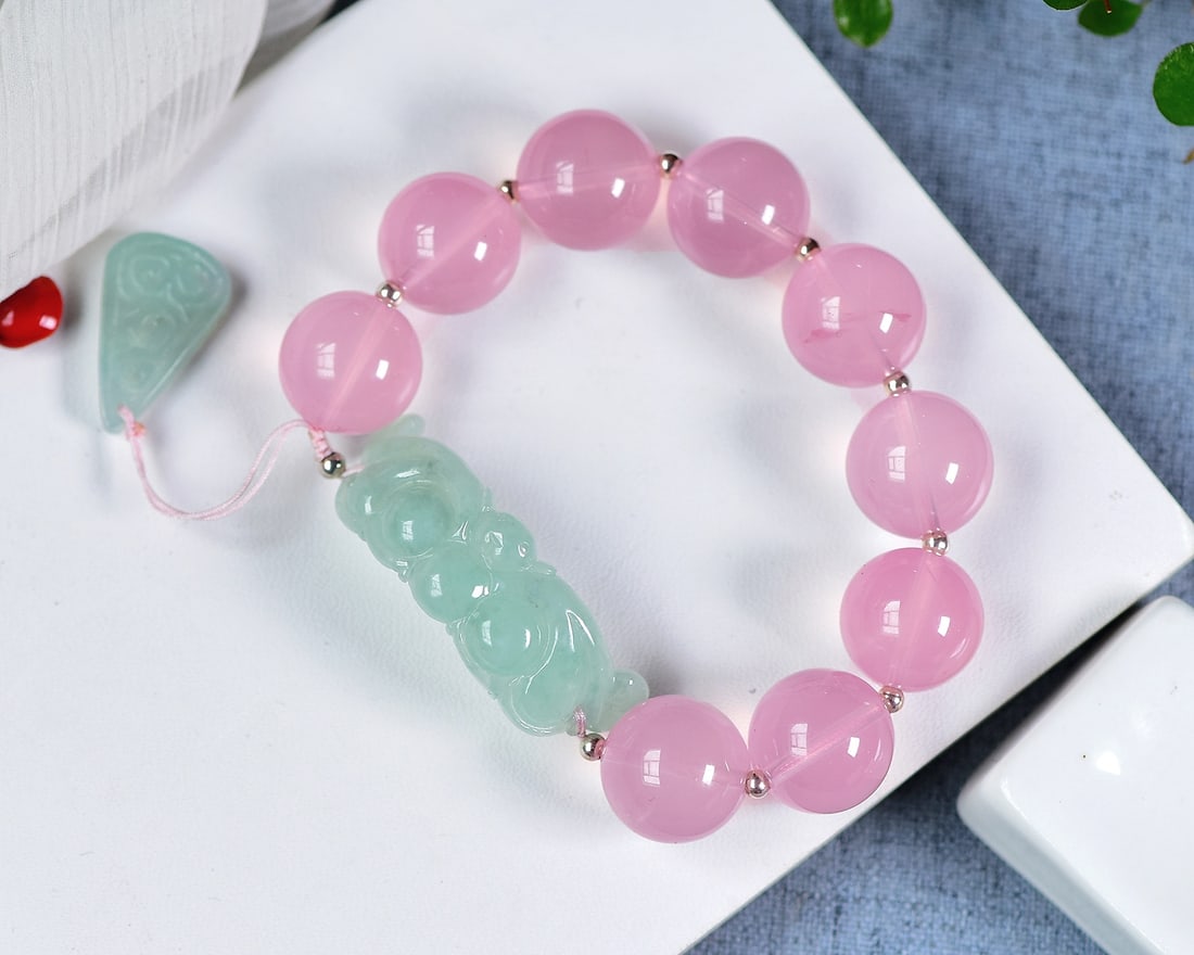 An Exquisite Natural Mozambican Starry Rose Quartz Round Bead Bracelet: An Exquisite Mozambican Starry Rose Quartz Round Bead Bracelet. Soft pink and watery hue with asterism, round beads interspersed with finely carved jadeite fittings. Bead diameter 15.5mm; weight: 56g.