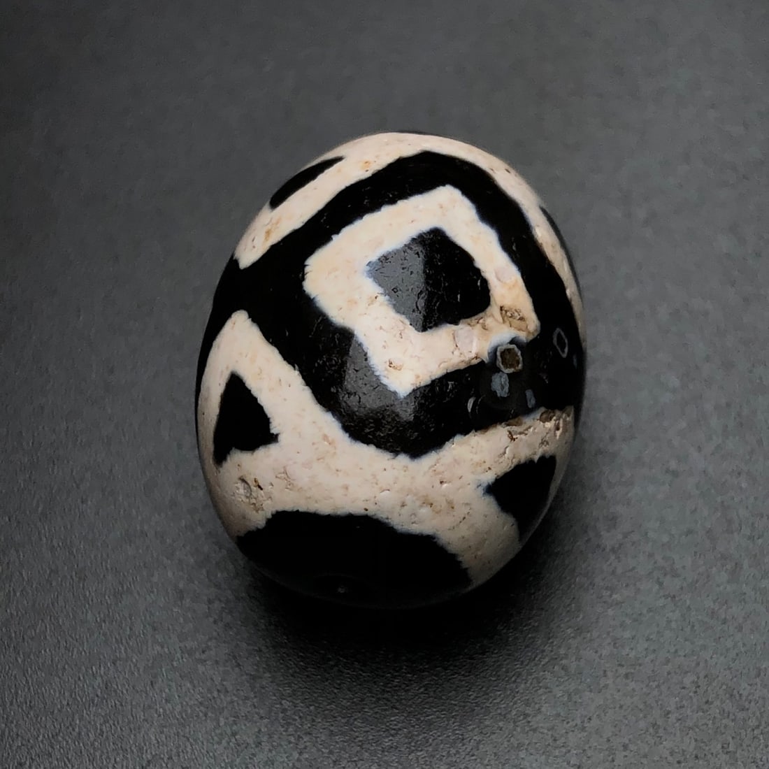 An Exquisite Old Material Daluo Vajra Three-Eyed Dzi Bead: An Exquisite Old Material Daluo Vajra Three-Eyed Dzi Bead. Rich oily patina, round bead form, clear totem. Size: 22mm×18mm; weight: 10.5g.