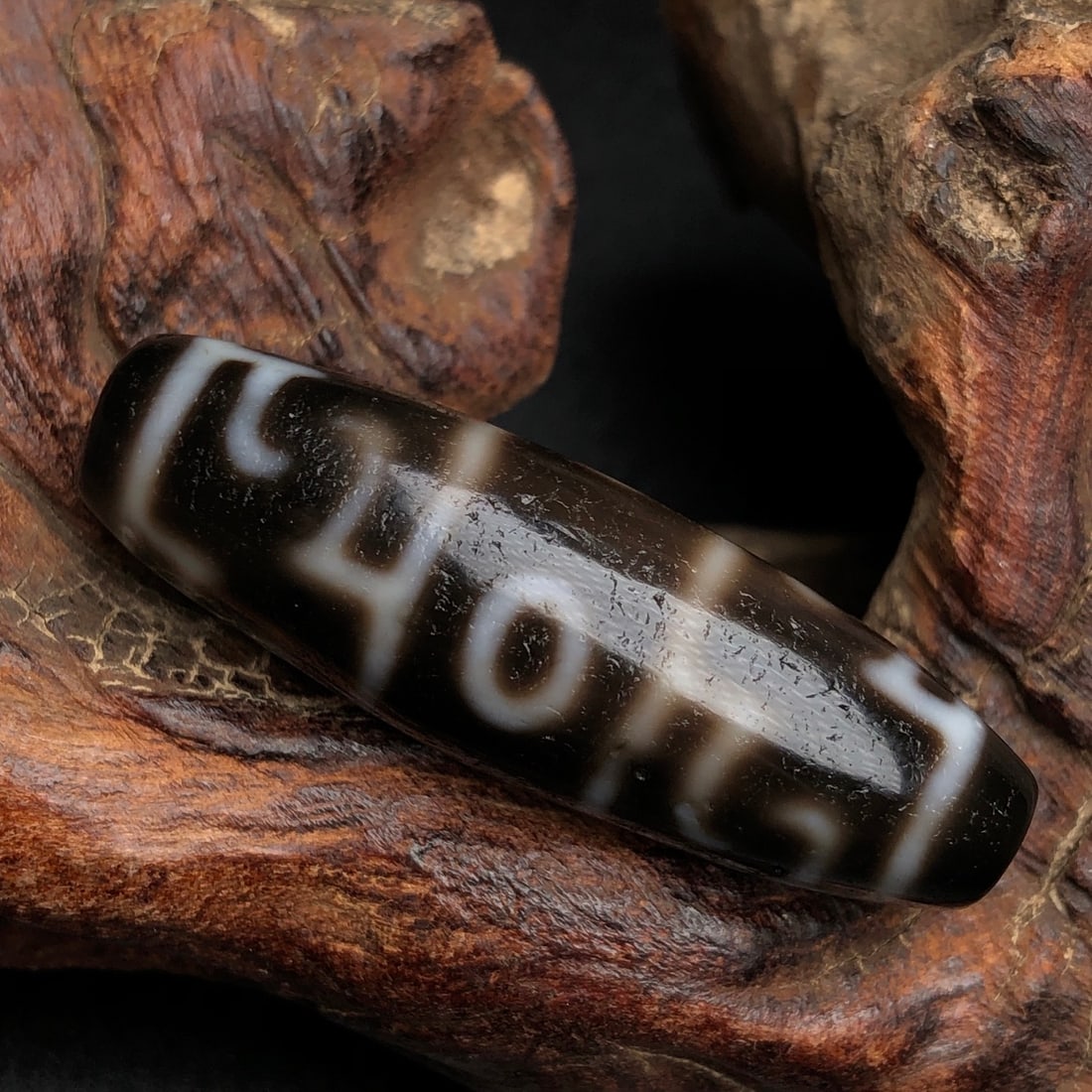 An Exquisite Old Material Guru Pema Three-Eyed Dzi Bead: An Exquisite Old Material Guru Pema Three-Eyed Dzi Bead. Rich oily patina, clear color contrast, fine texture, weathering, clear totem. Size: 39mm×12mm; weight: 8.6g.