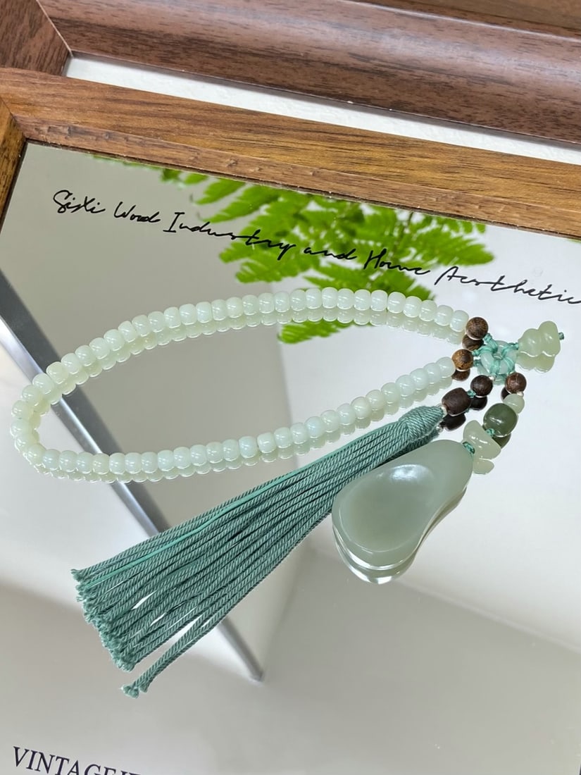 A Finely Carved Hetian Jade 'Qiemo Blue' Handpiece: A finely carved Hetian jade handpiece of Qiemo blue quality, of freeform shape, designed for tactile enjoyment. The jade is of fine, oily texture with a smooth, warm finish, offering a satisfying