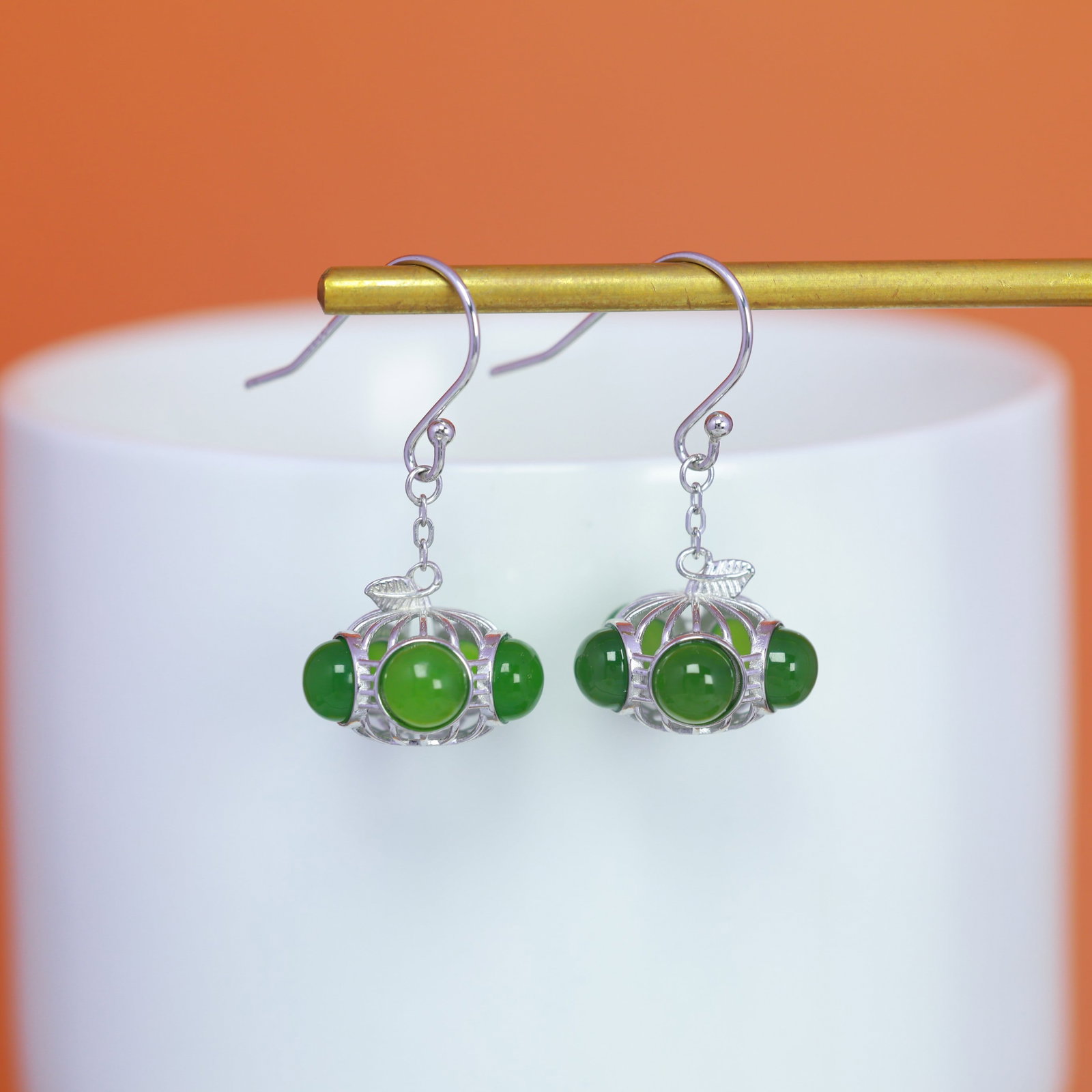 A Pair of Sterling Silver and Hetian Jasper Drop Earrings: A pair of sterling silver drop earrings, each set with Hetian jasper, Sise: 5mm×5 mm. 纯银镶和田碧玉耳坠；主石为Ø