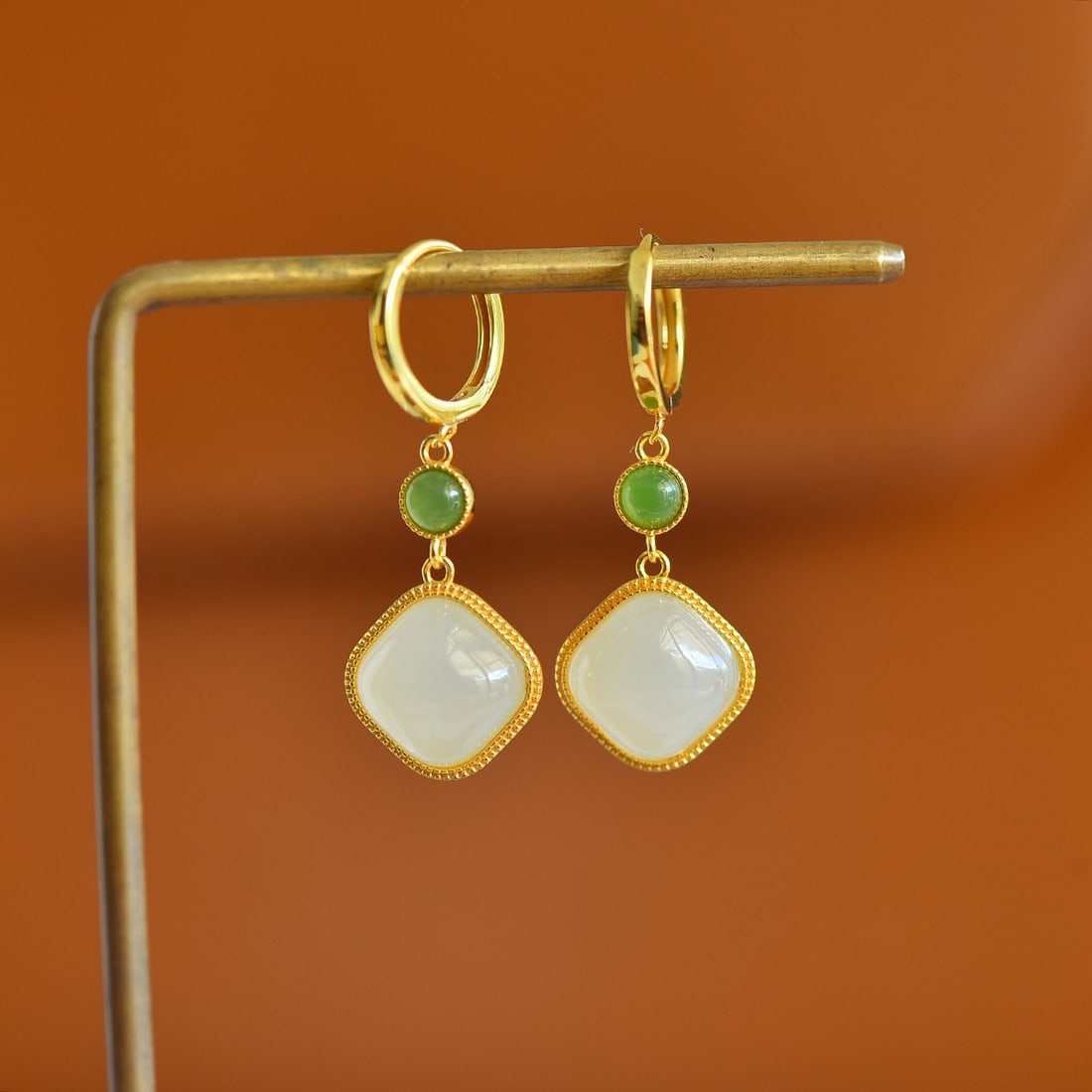 A Pair of Sterling Silver and White Jade Square Earrings: A pair of sterling silver earrings, each set with a white jade of square form, Sise: 10mm×10 mm. 纯银镶白玉方形耳扣；主石&#