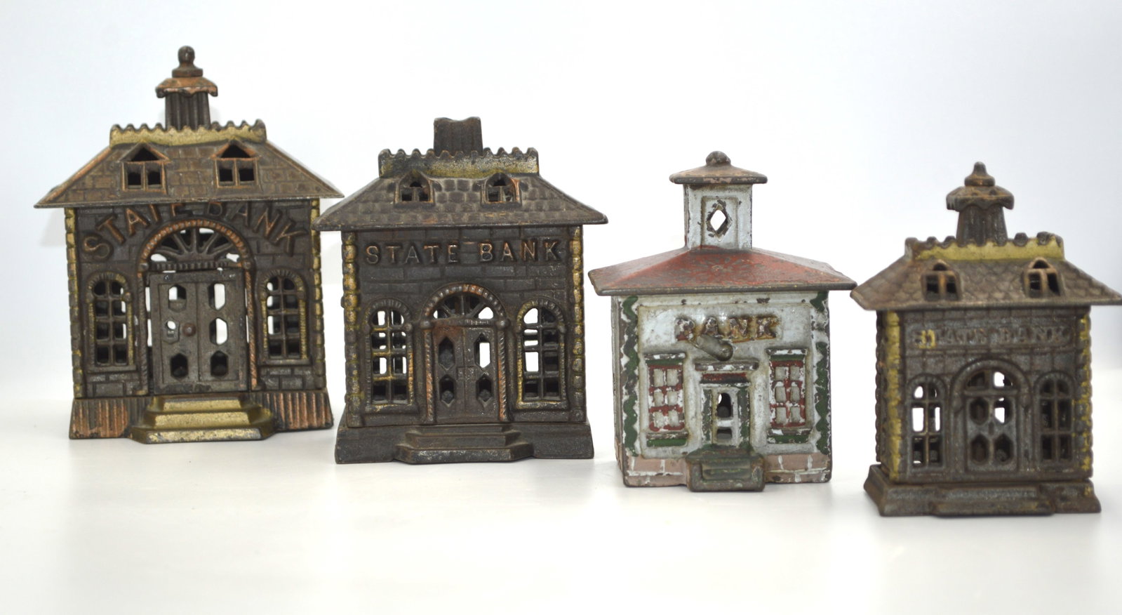 Four Cast Iron Piggy Banks: Description: 4 antique iron piggy banks