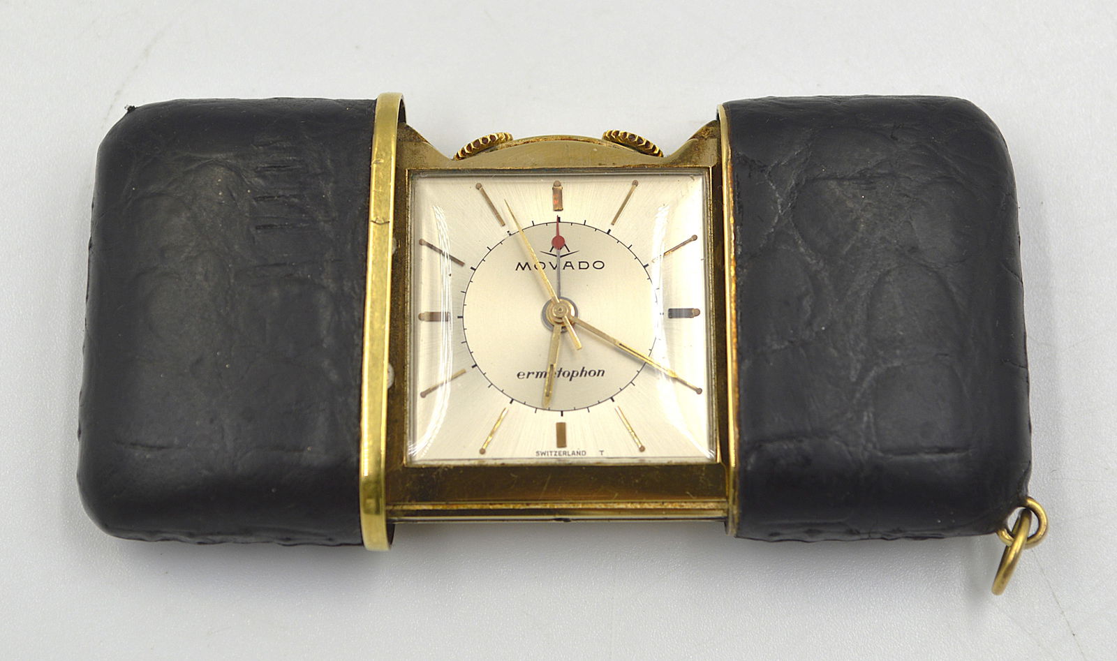 Movado Ermeto Swiss Alarm Clock in Leather Case: Movado Ermeto Swiss alarm clock in leather case In working condition Measures: 3 inches wide (open)