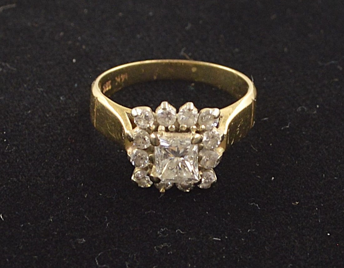 Diamond Ring with Twelve Diamonds: Ladies size 5 diamond ring with large central stone flanked by 12 smaller diamonds Details: Ring stamped 14k and 18k gold Weight: 3.6 grams