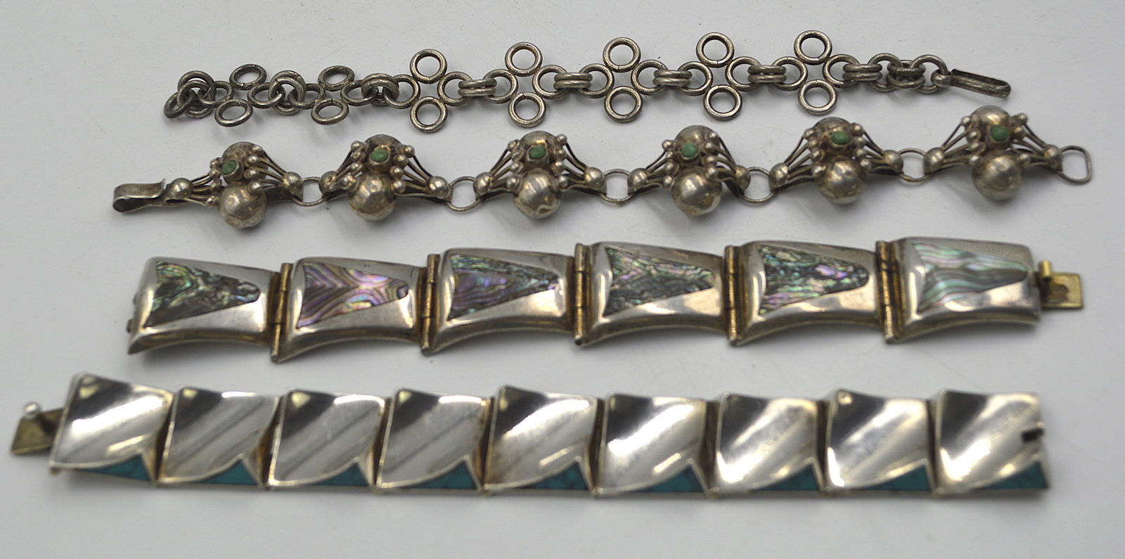 Two Signed Taxco Bracelets and Two Silver Bracelets: Two signed vintage Taxco sterling silver bracelets, together with two additional silver bracelets Total weight for all: 140 grams Bracelets measure 7 inches in length