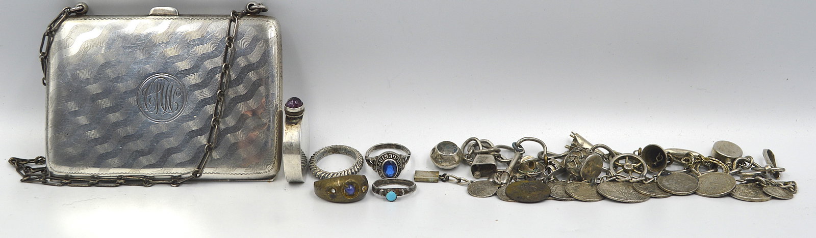 Silver Jewelry Lot: 2 silver charm bracelets, 4 silver rings, silver perfume bottle, a sterling silver change purse Total weight: 200 grams "