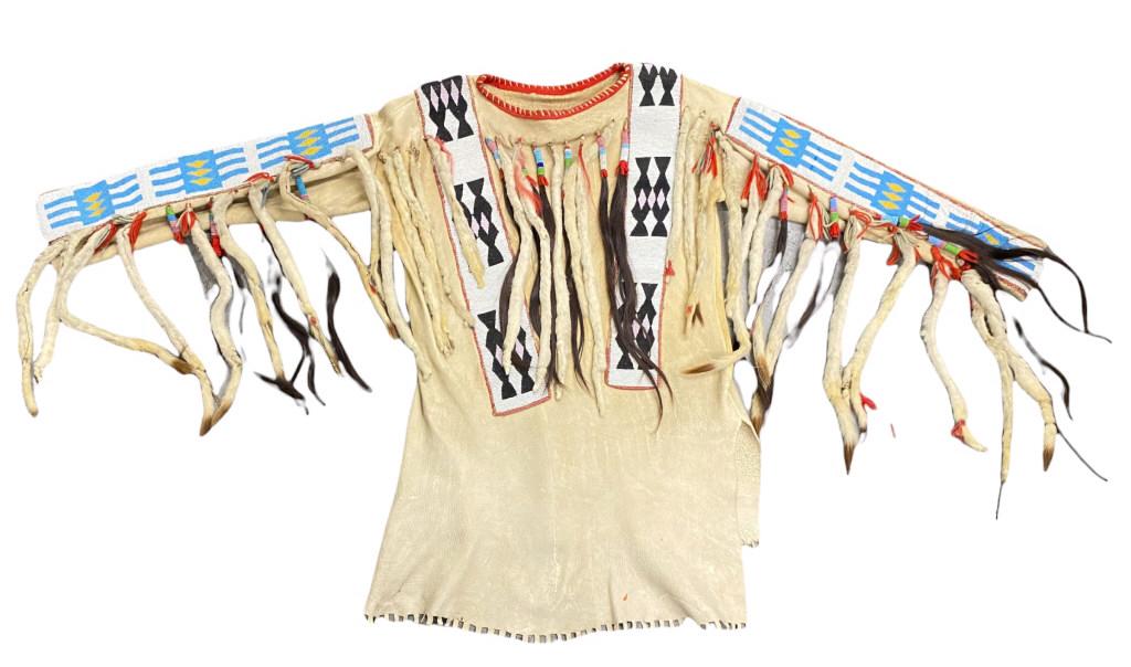 Blackfoot War Shirt Northern Plains Cir. 1890-1910: Comes with Christy Lee Fine Arts Paperwork from 1988. "...made of native tanned deerhide, decorated with very wide, elaborated, beaded strips. beaded hair, and weasel drops. The shirt measures 68 inch