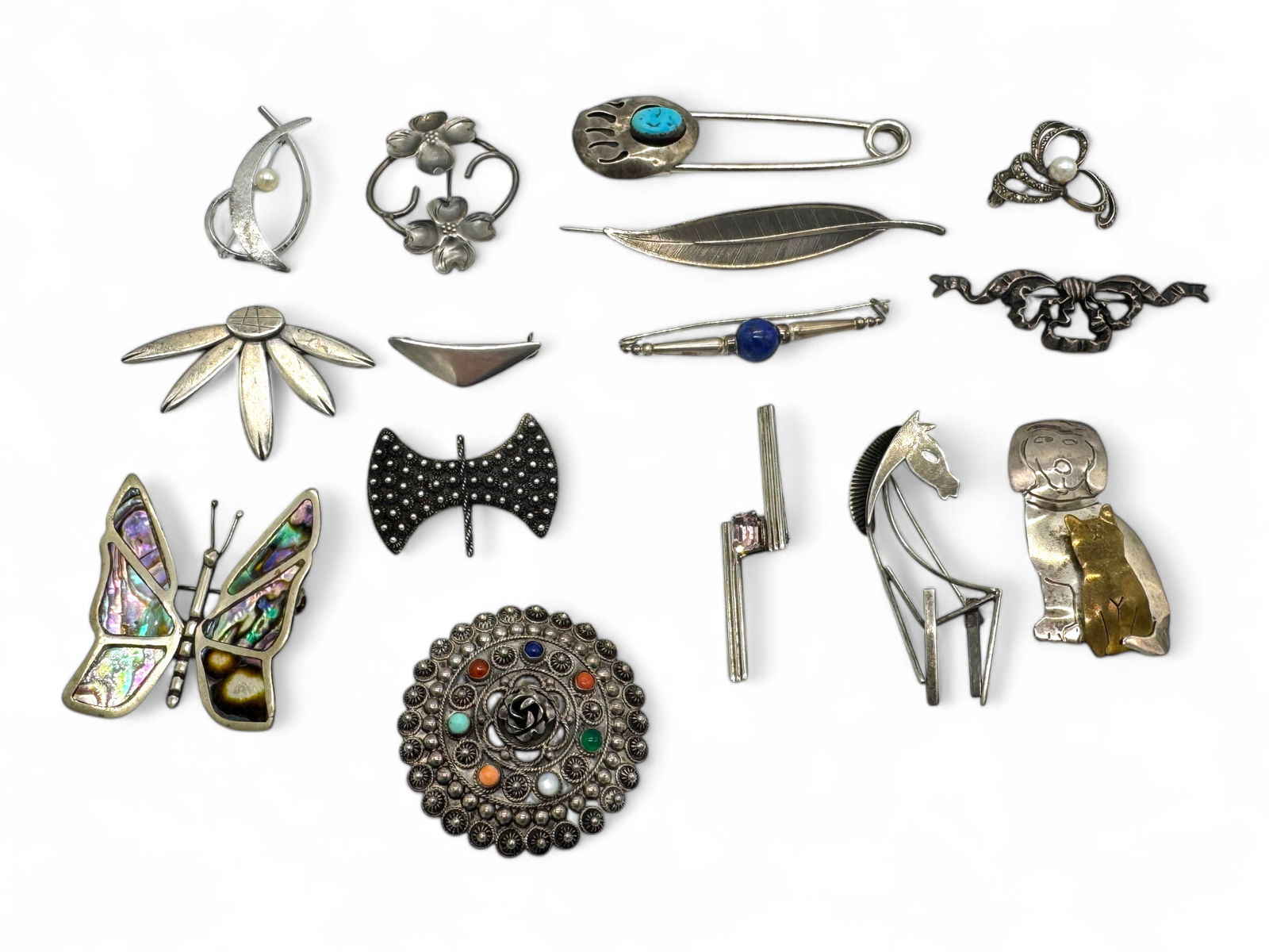 (15) Sterling Silver & Stone Brooches: (1) marked "Hans Hansen Denmark", all marked "Sterling", mother of pearl, turquoise, coral & lapis Size: 1 1/2"-3 1/4" Weight: 115g Condition: good, minor scratches