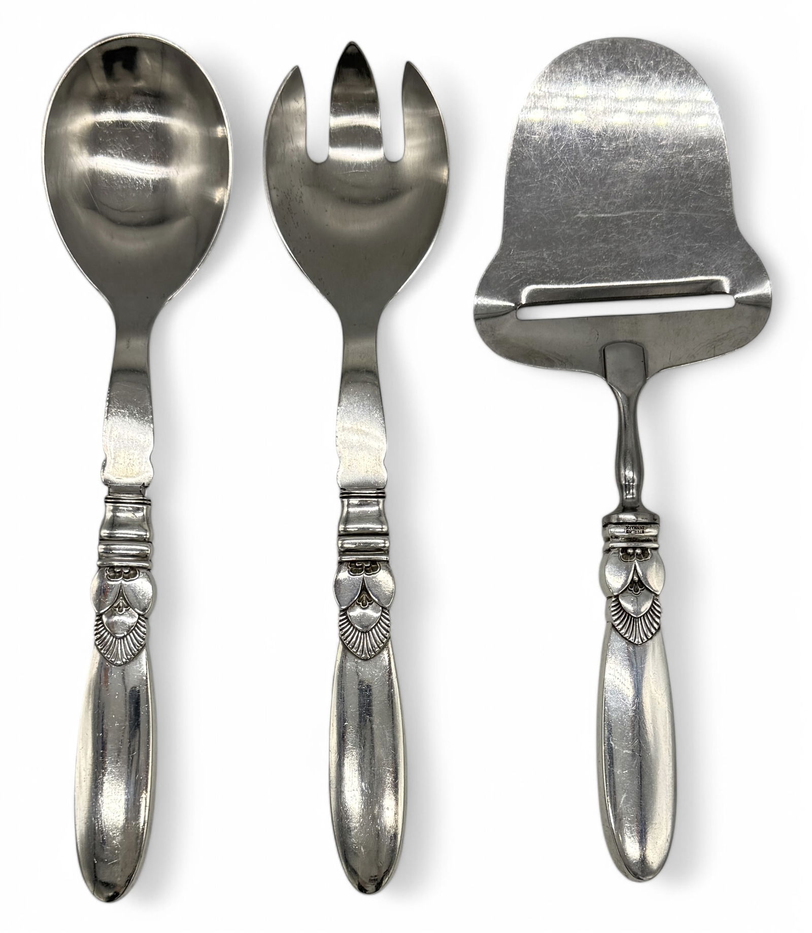 (3) Georg Jensen Cactus Sterling Handled Serving Pieces: Cheese plane & salad serving set, designed by Gundorph Albertus in 1930, marked “Sterling Denmark” on handles & maker mark.Salad Set: 8 1/4” longCondition: minor scratches co
