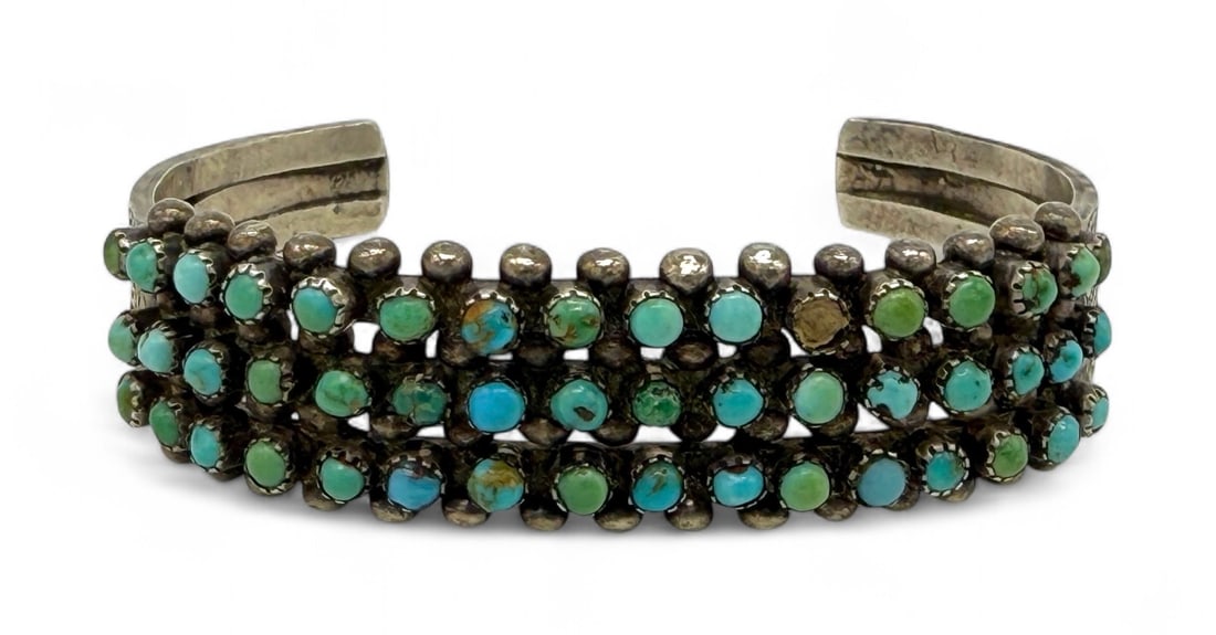 Zuni Sterling Silver & Turquoise 3-Row Cuff: Three rows of 2mm turquoise rounds set in saw tooth edges. Size: 5 1/2" with a 1 1/4" opening Width: 1/2" Weight: 24g Condition: Good with scratches and tarnish. One stone is missi