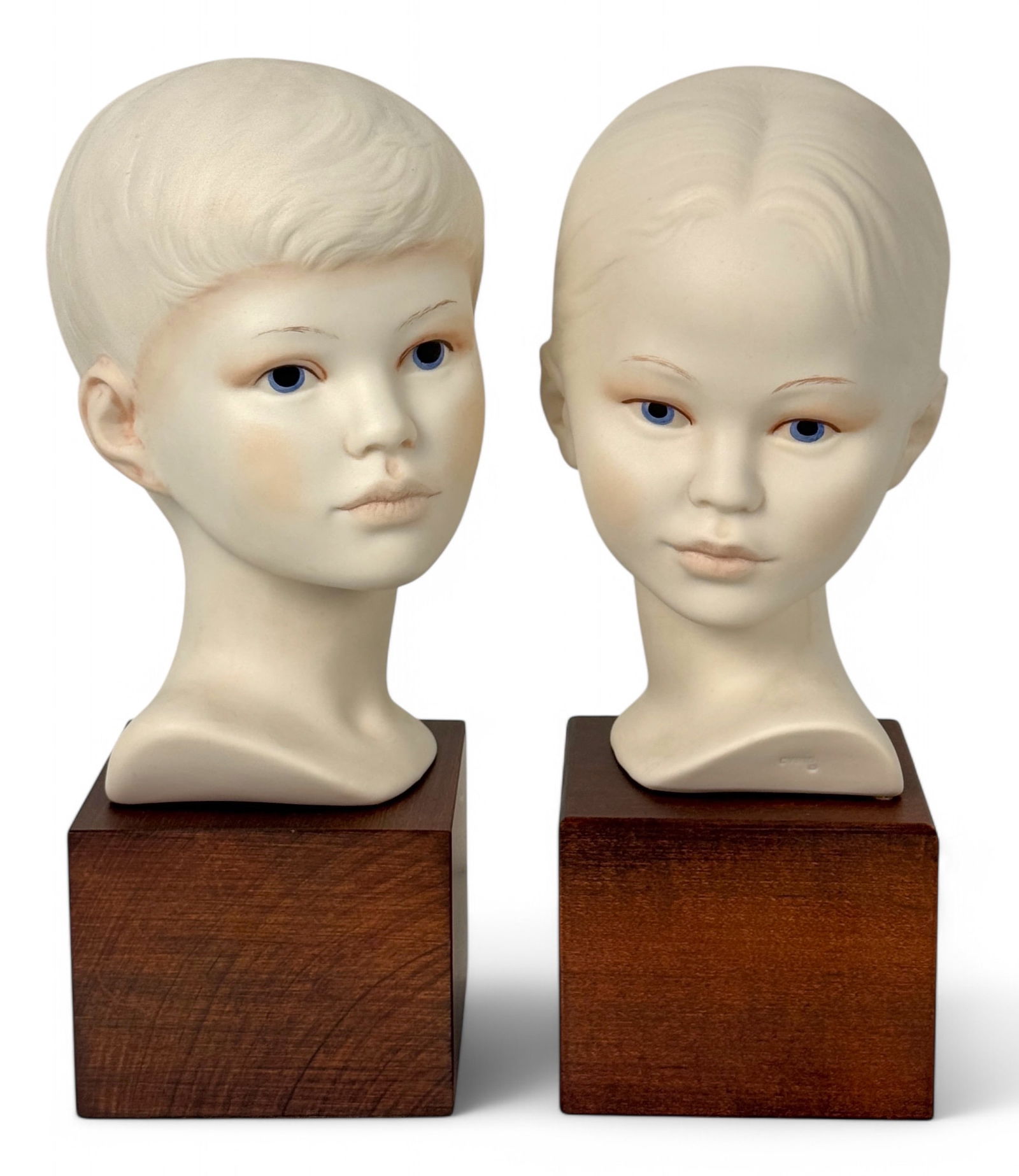 Cybis Porcelain Child Busts: Signed unglazed hand-painted boy & girl busts on wooden bases. Height: 9" Cube Base: 3 1/2" x 3 1/2" x 2 1/4"H Condition: Very good, no chips or cracks. 