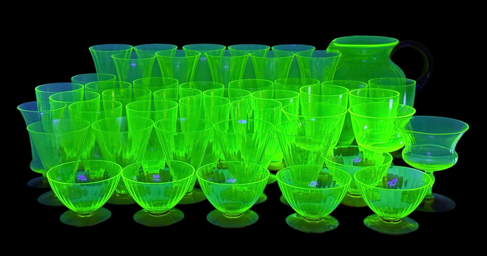 (26pc) Uranium Large Set Of Glassware: (1) Sunday Glasses 5" (5) Small Sunday Glasses 4 1/2" (6) Berry Bowls (10) Wine Glasses (3) Stemmed Dessert Cups (1) Champagne Pitcher Condition: Three of the pieces h