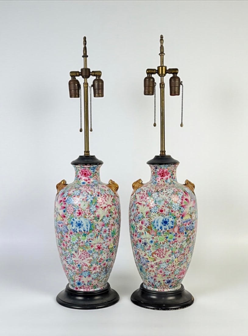 Pair of Chinese Famille Rose Porcelain Lamps with Gilt Bat Handles: Height: 32” Condition: Areas of paint loss and chipping to the wooden bases and upper rims, as shown. Light surface wear consistent with age and use; otherwise, in good working condi