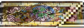 Stained Glass Panel With Hand Painted Grapevine Motif: Dimensions: 13” x 40 1/4” Condition: Overall good condition with minor surface wear and light scratches consistent with age. A few panels show small hairline fractures,