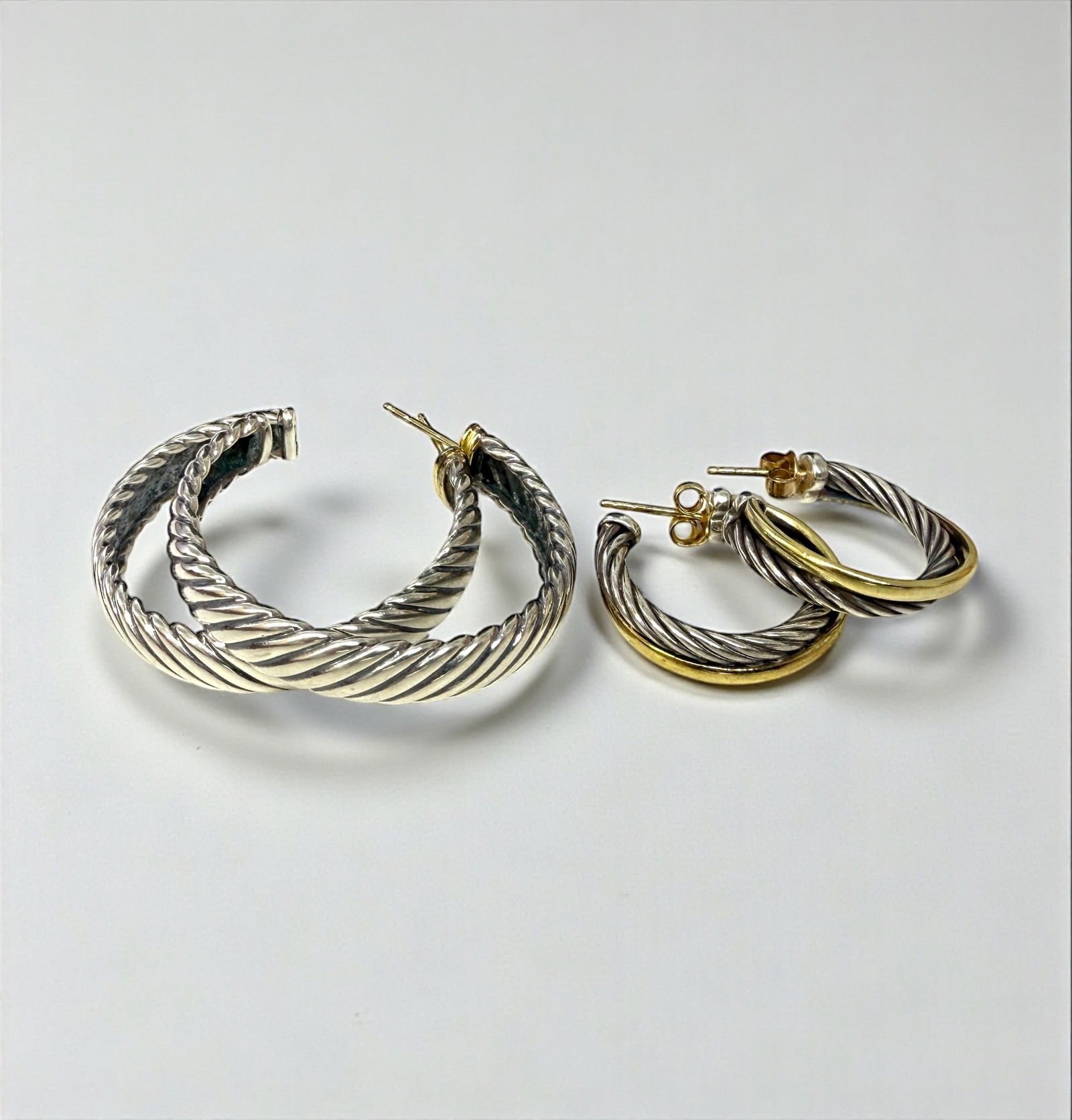 (2) Pairs Of David Yurman 18K and Sterling Earrings: Diameter of Smaller Pair: Slightly less than 1" Diameter of Larger Pair: 1 1/2" Condition: Good with some surface scratches with tarnishing visible on both pairs, and the