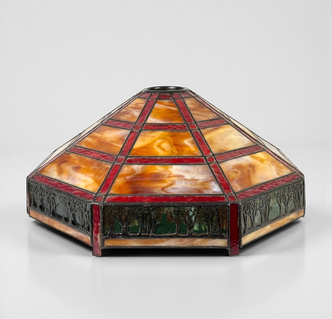Large Stained Glass Lamp Shade: Style of Bradley & Hubbard. Tree motif. Dimensions: 14 1/2" x 27" Condition: A few cracked and broken glass panels and some minor separation of the frame near the bottom of the sh