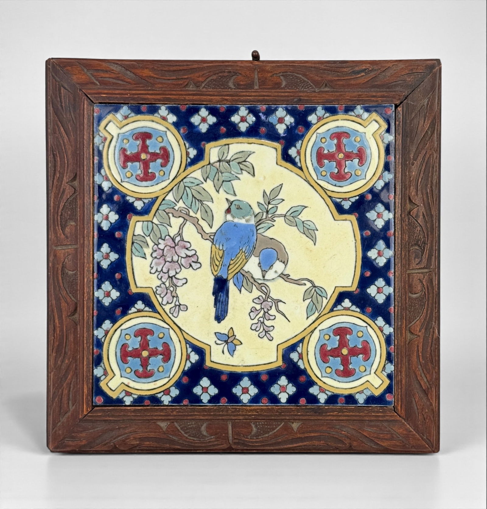 Music Box Trivet Mounted With A Faience Ceramic Tile: Vintage sticker applied to the back Dimensions: 11" square x 3" deep Condition: Wear and surface marks to the wooden frame, with minor separation at the mitered corners. The tile is i
