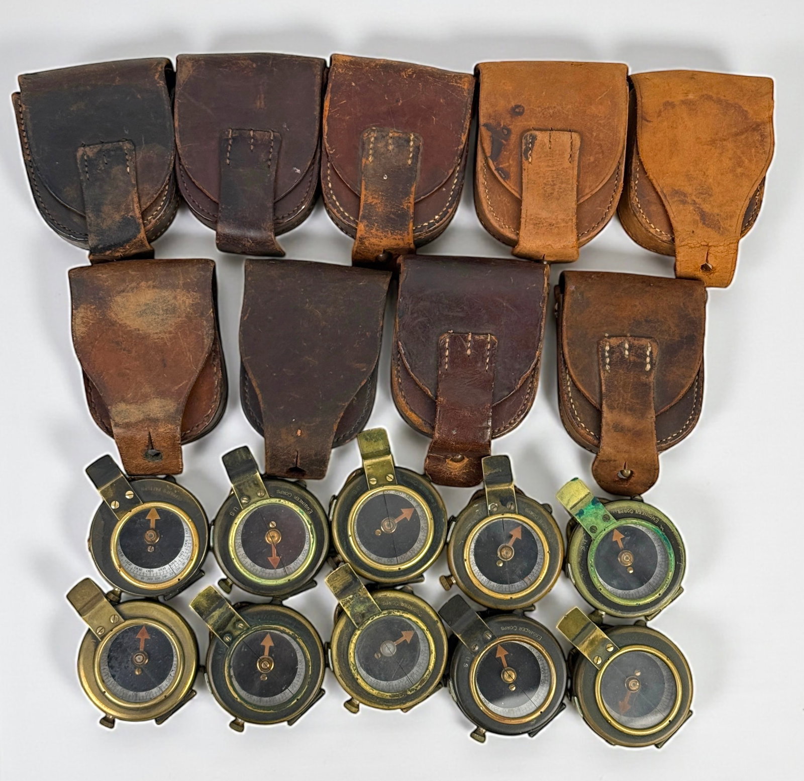 Group Of (10) WWI Military Compasses (J): With (9) Leather Cases Size: Each 2" Diameter Condition: Mixed condition throughout with wear, tarnish, scratches, and scattered oxidation from age and use. Working but untested for a
