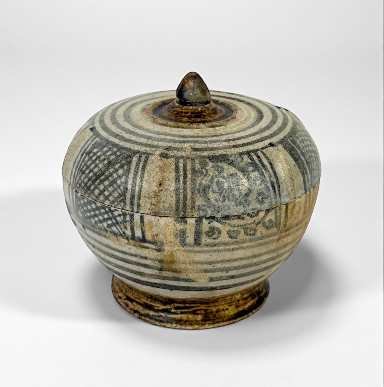 Thai Sawankhalok Porcelain Covered Jar: Dimensions: 4 1/2” x 4 1/2” Condition: Small chips along the interior and bottom rim. Areas of paint loss and age-related discoloration throughout. Light surface wear consistent with
