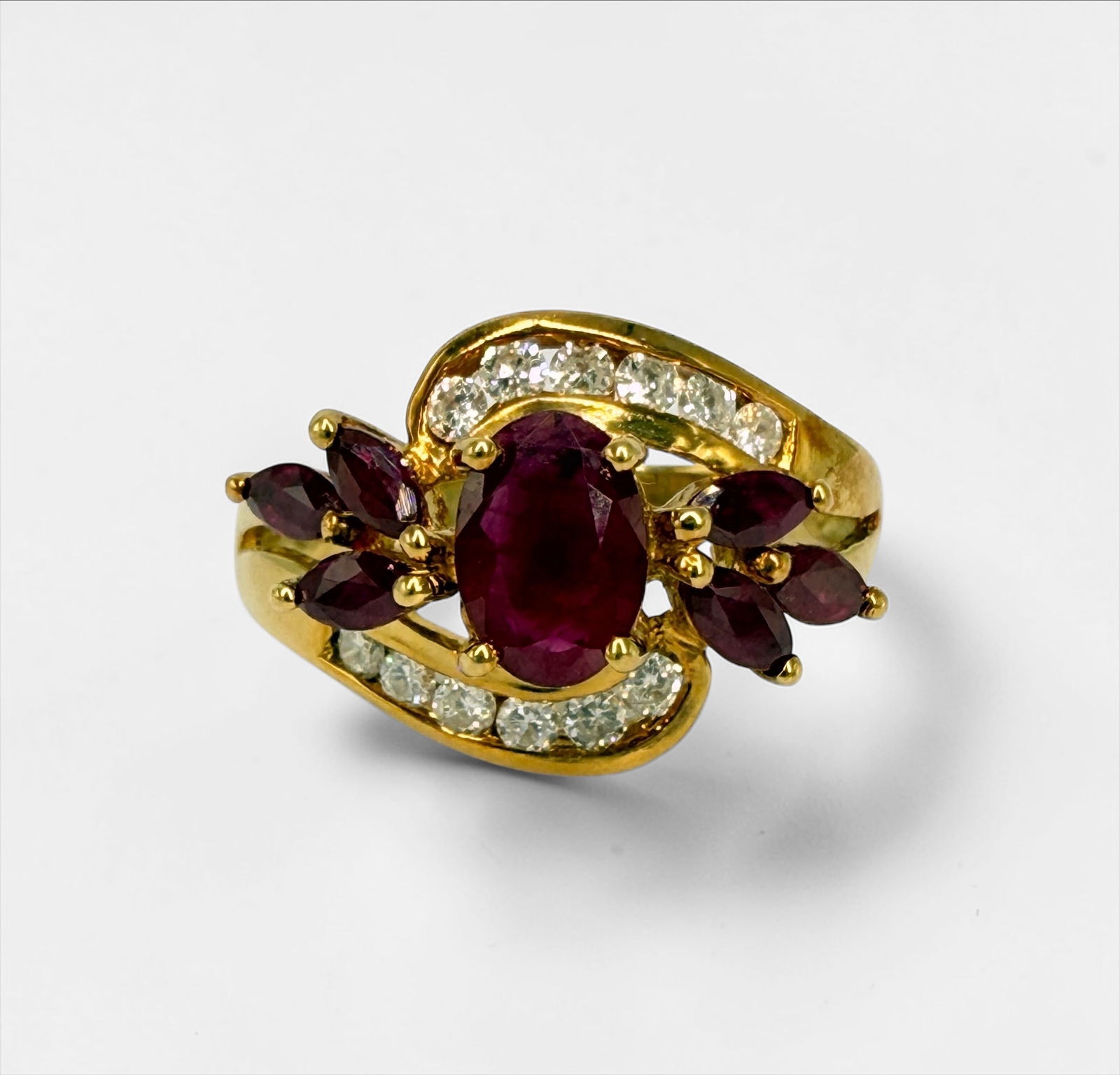 7.84CTTW Ruby Ring Set in 18K Gold: Size: 6 Total Weight: 4.6g Per Appraisal: One 18kt yellow gold ladies ruby and diamond ring. Center stone is 5x7mm ocal ruby, accented by six 2x3mm marquise cut rubies. Rubies have good color and are