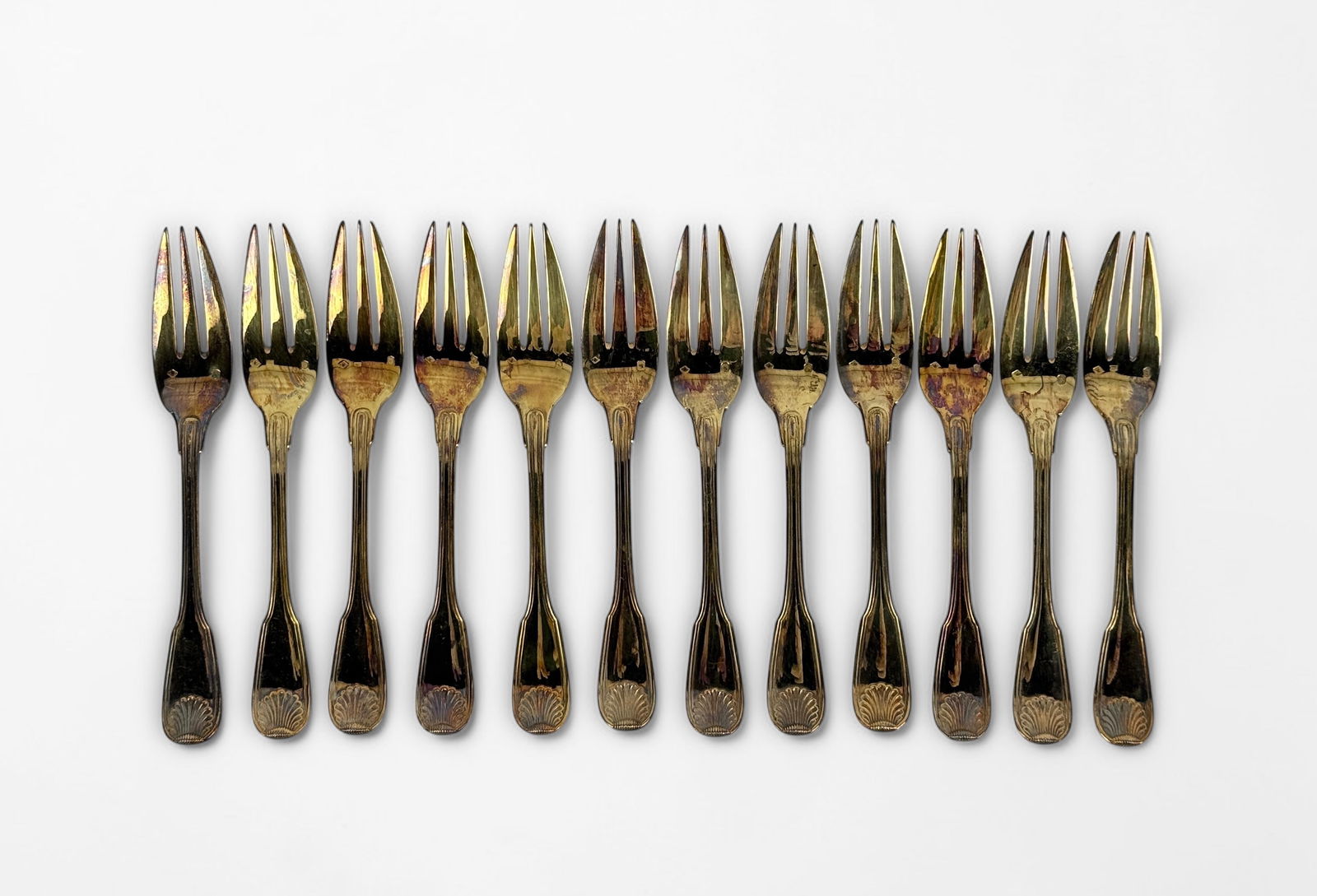 (12) Puiforcat Vermeil Silver Dessert Forks: In box. Fork Length: 5 3/4" Weight: 379g Condition: Various levels of tarnishing. Hallmarks on the root of the forks, no monograms. See images for details. 