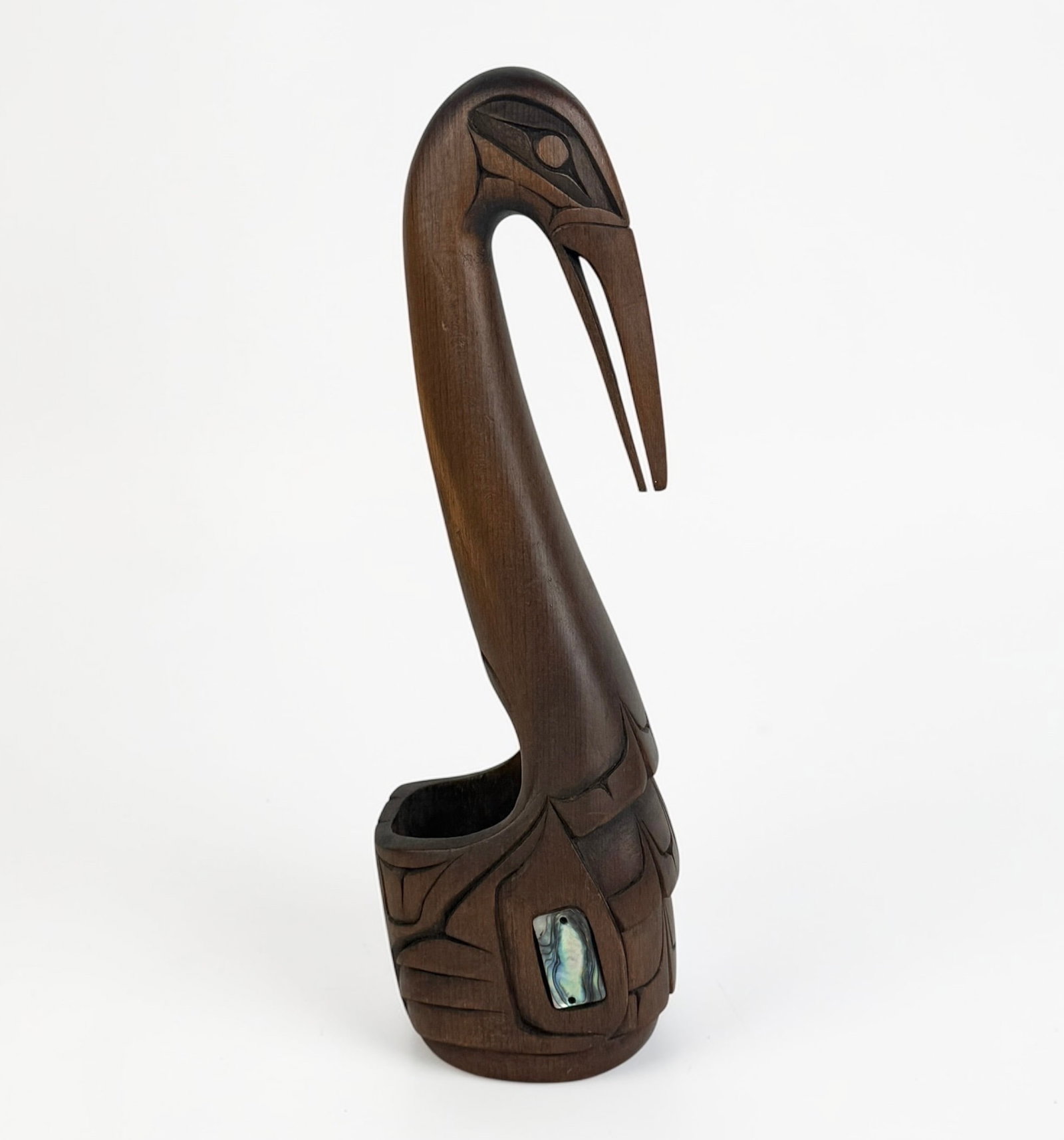 William Wadhams Kwakiutl Bird Carving: Bowl Depicting Crane. Stained red cedar with abalone inlay. Signed on the bottom. Dimensions: 11 1/2" x 3" x 3 1/4" Condition: Minor scratches to the