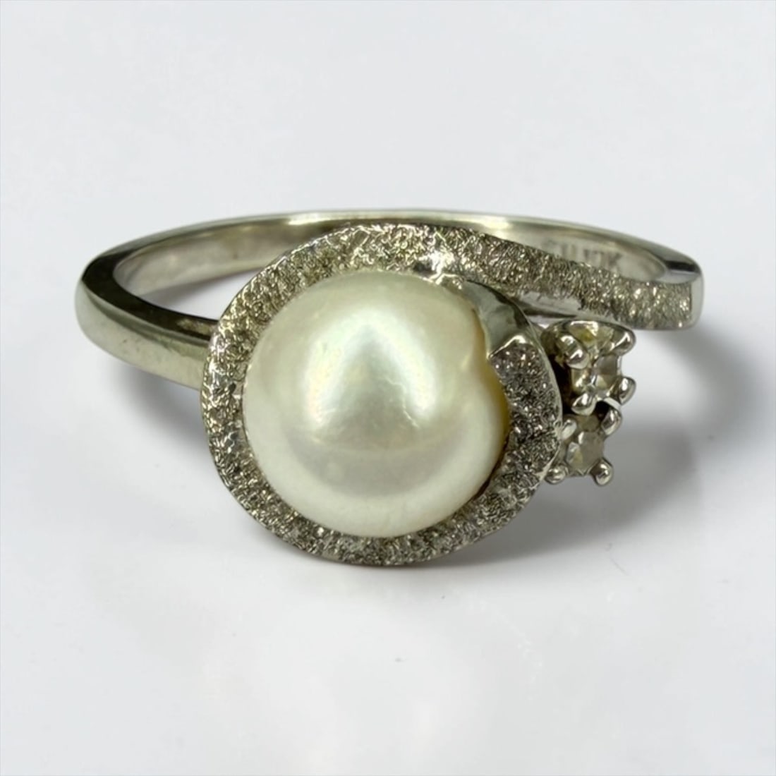 Ladies 10K White Gold & Pearl Ring: Size: 6 1/2Weight: 2.5gDimensions: 8.6mm diameter setting Condition: The ring is in good condition. The two side stones have been tested and are not diamonds. 