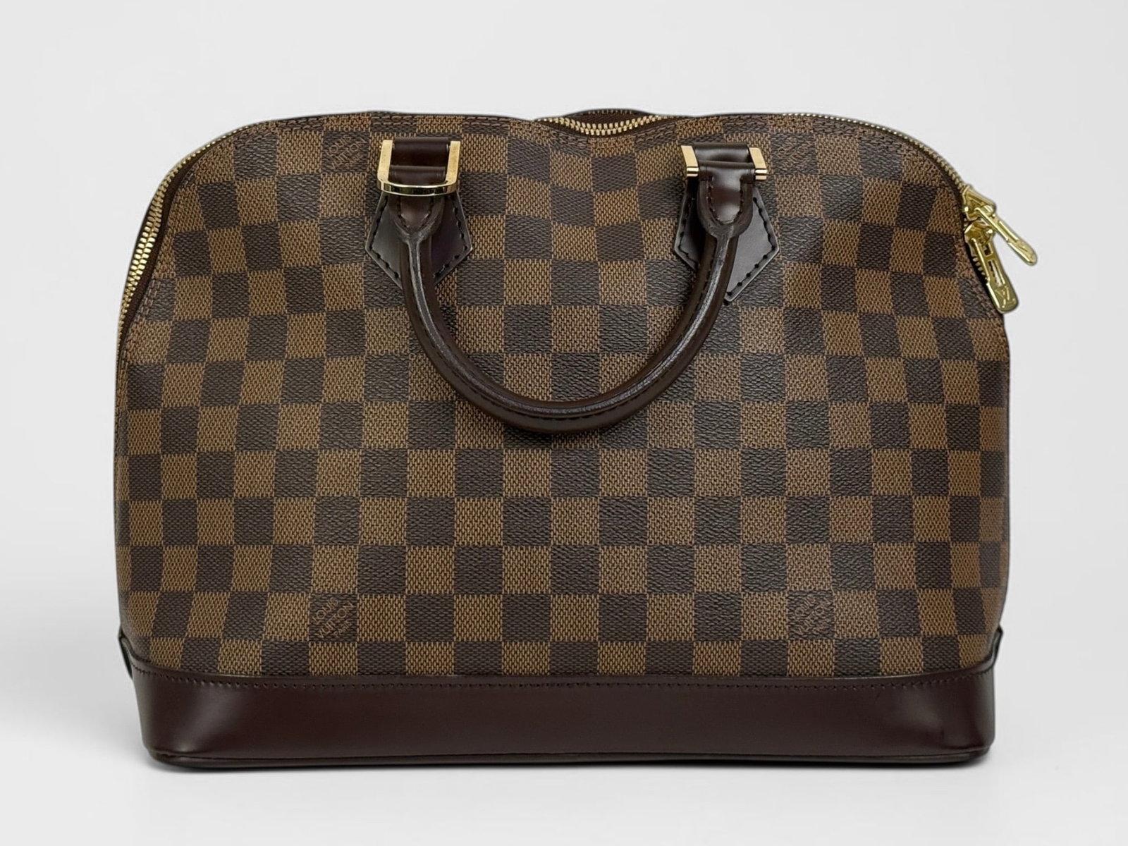 Louis Vuitton Alma Brown PM Hand Bag: Damier Ebene coated canvas with textile interior and leather trim. Two interior pockets with brass hardware. Dimensions: 9" x 12" x 6" Condition: The bag is in