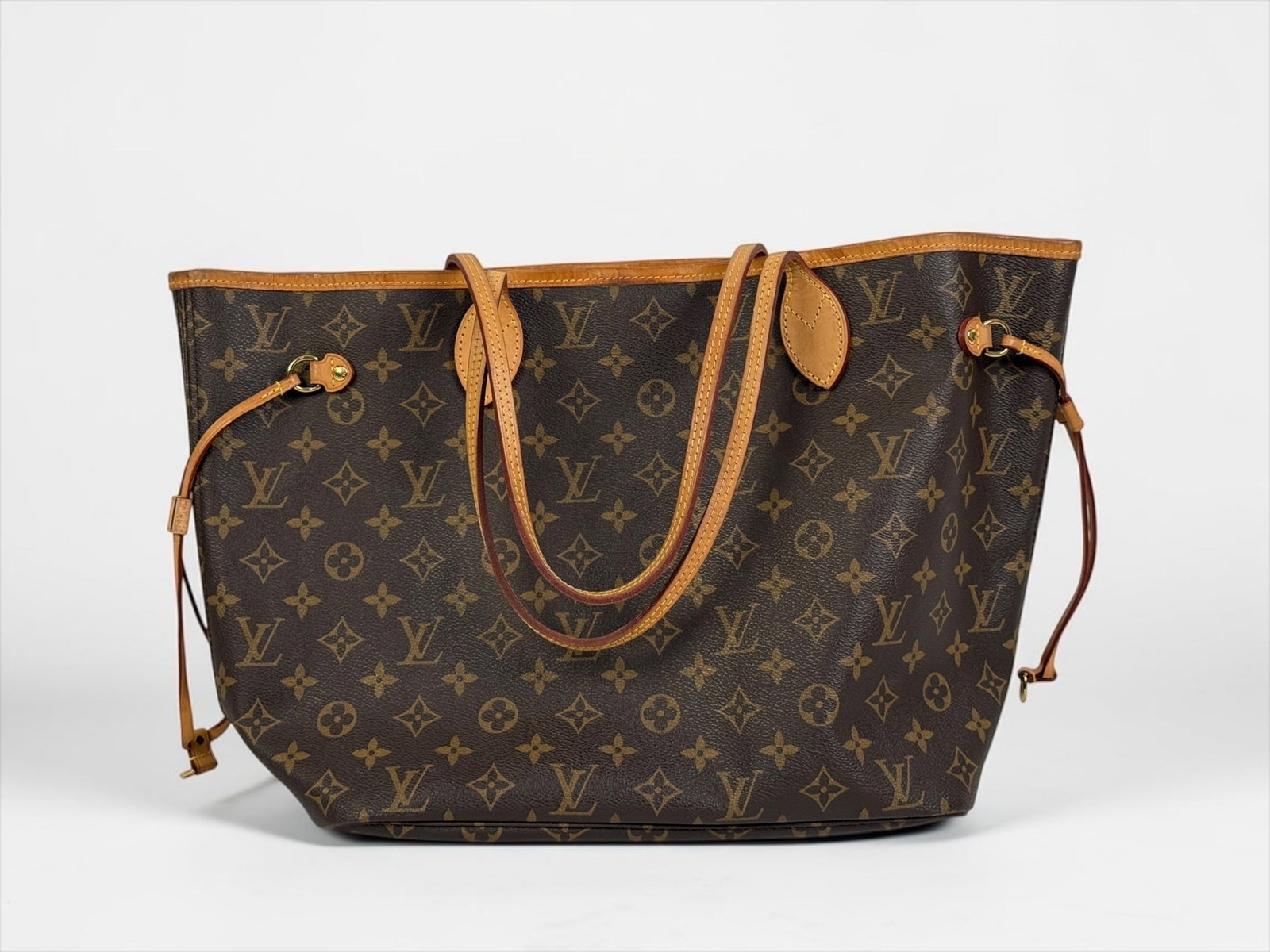Louis Vuitton Neverfull Monogram Tote: From the 2011 Collection by Marc Jacobs Brown coated canvas with LV monogram. Canvas interior. Brass hardware and leather trim with dual shoulder straps. Clasp closure at top with single i