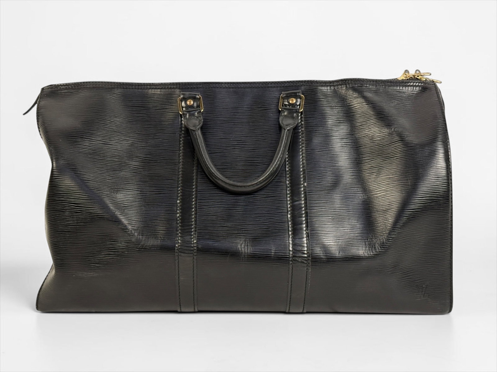 Louis Vuitton Keepall 50 Black Duffel: Black textured epi leather with suede interior. One external pocket and brass hardware. Dimensions: 11" x 20 1/2" x 9" Condition: Minor wear to the leather and
