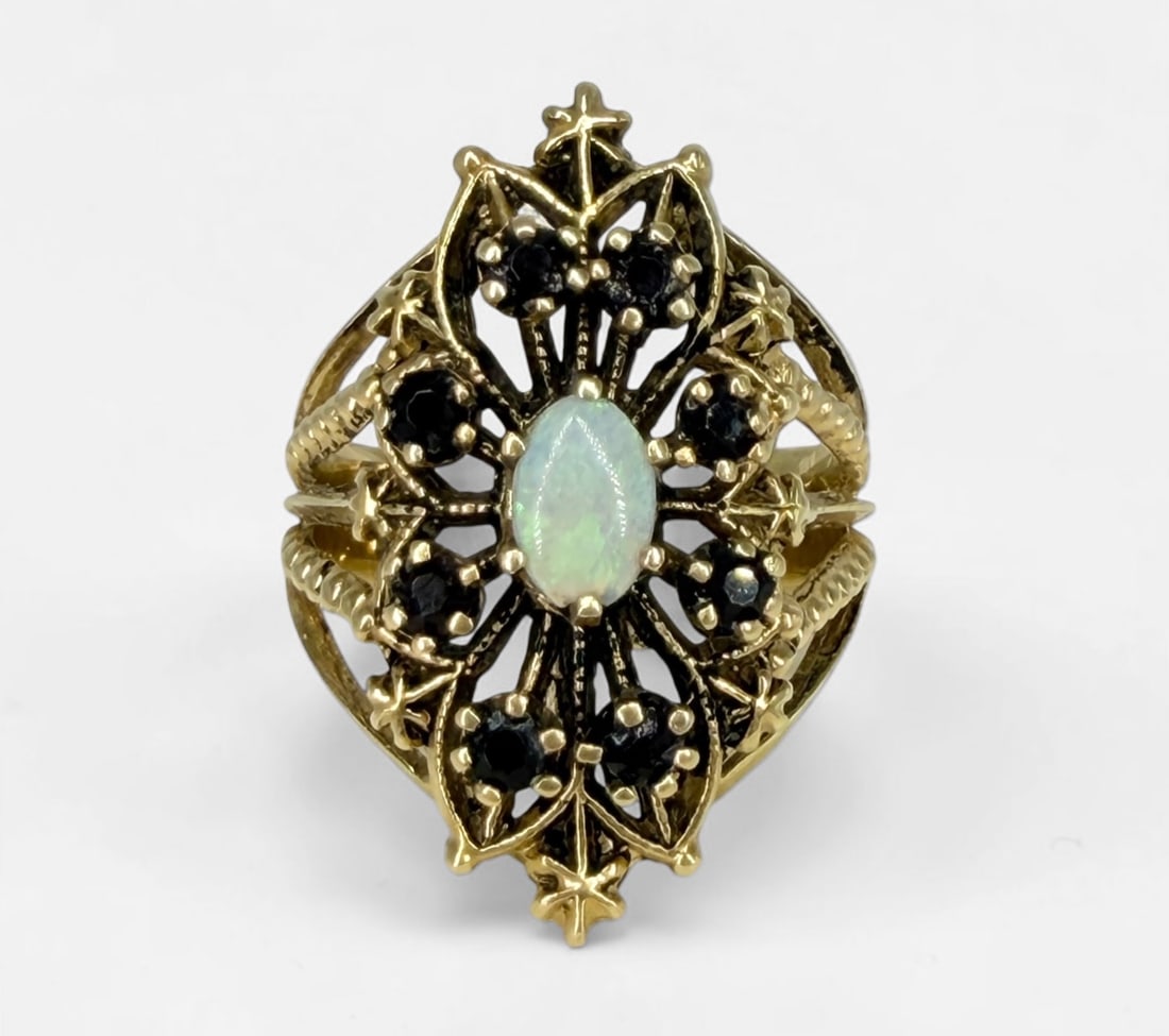 14K Gold & Opal Ladies Cocktail Ring: Opal with garnets. Size: 6.5 Weight: 6.8g Opal: 6mm x 4mm Condition: Good.