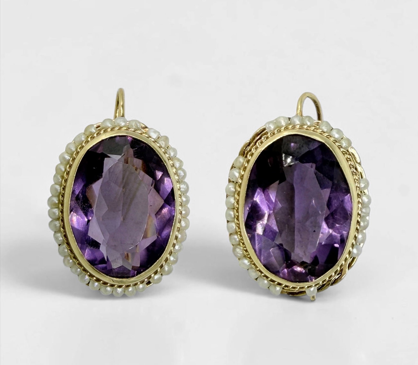 14K Yellow Gold Earrings W/ Large Amethyst and Pearls: Size of Each Amethyst: Approximately 16mm x 13mm Length Of Earrings: 21mm Total Weight: 7.6g Condition: Fair (Note: Some pearls are missing on one earring)